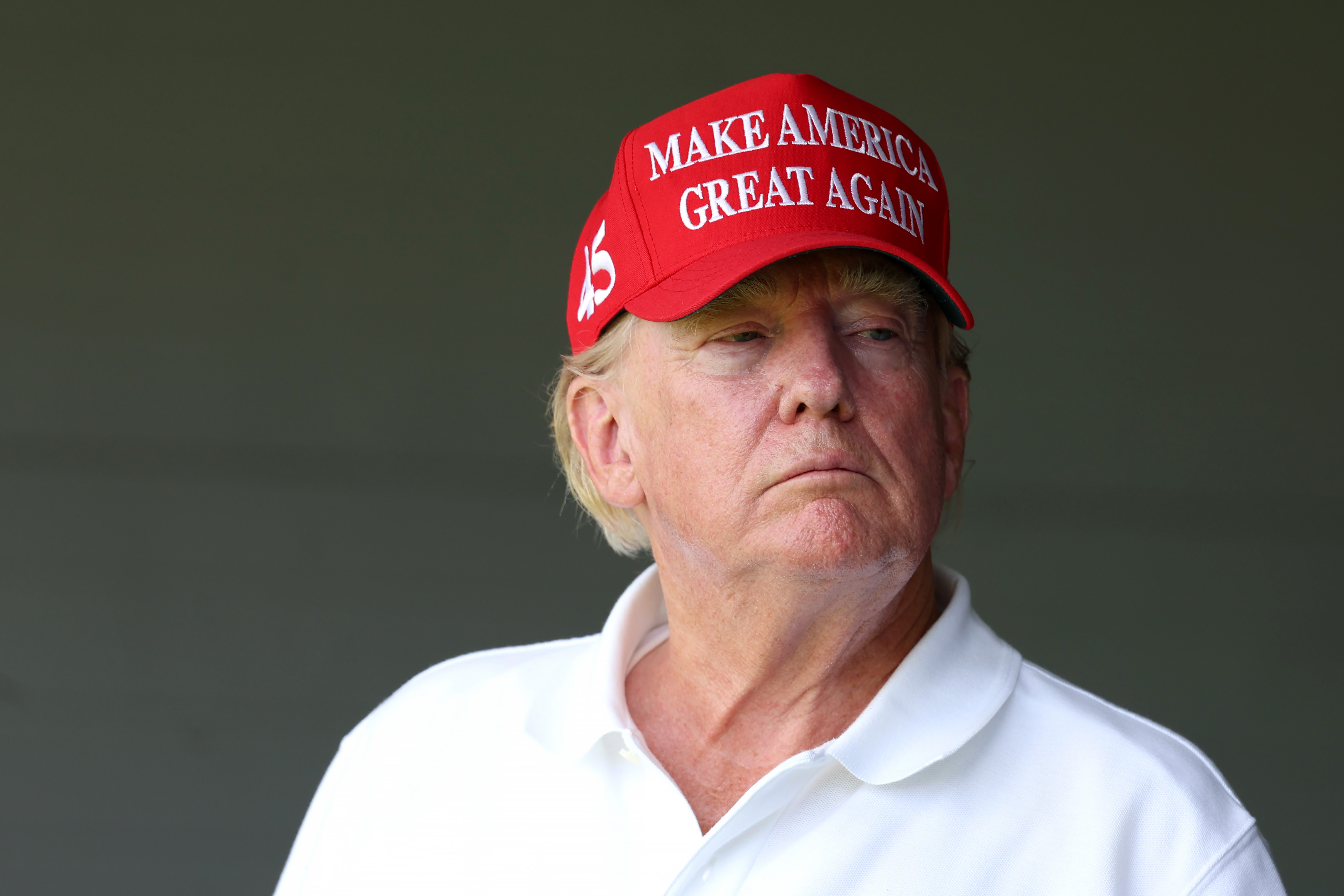 El 26 de mayo, Donald Trump observa desde una zona de sombra con el mismo sombrero rojo y la misma camisa blanca. El tono de su piel parece más uniforme con la luz más tenue, aunque la coloración roja sigue siendo fuerte cerca de sus mejillas.