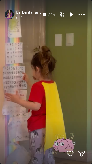 Sarah Burlando en su habitación jugando con un educativo cartel con números que le instaló su mamá | Fuente: Instagram Stories/barbaritafranco21