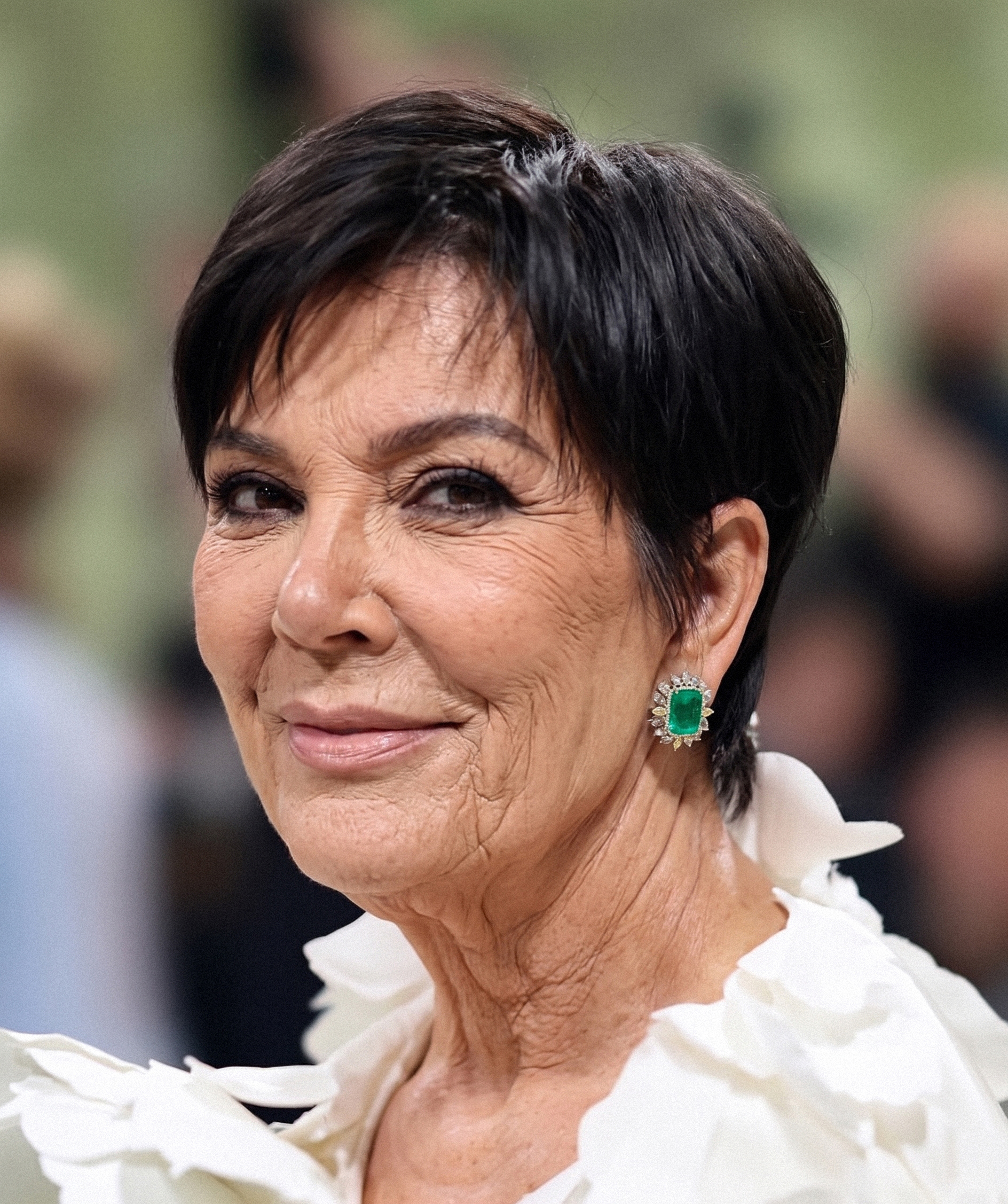 Un primer plano imaginado sin retoques estéticos, con arrugas visibles alrededor de los ojos y la boca que le dan un aire claramente natural al aspecto tan característico de Kris Jenner. | Fuente: Gemini