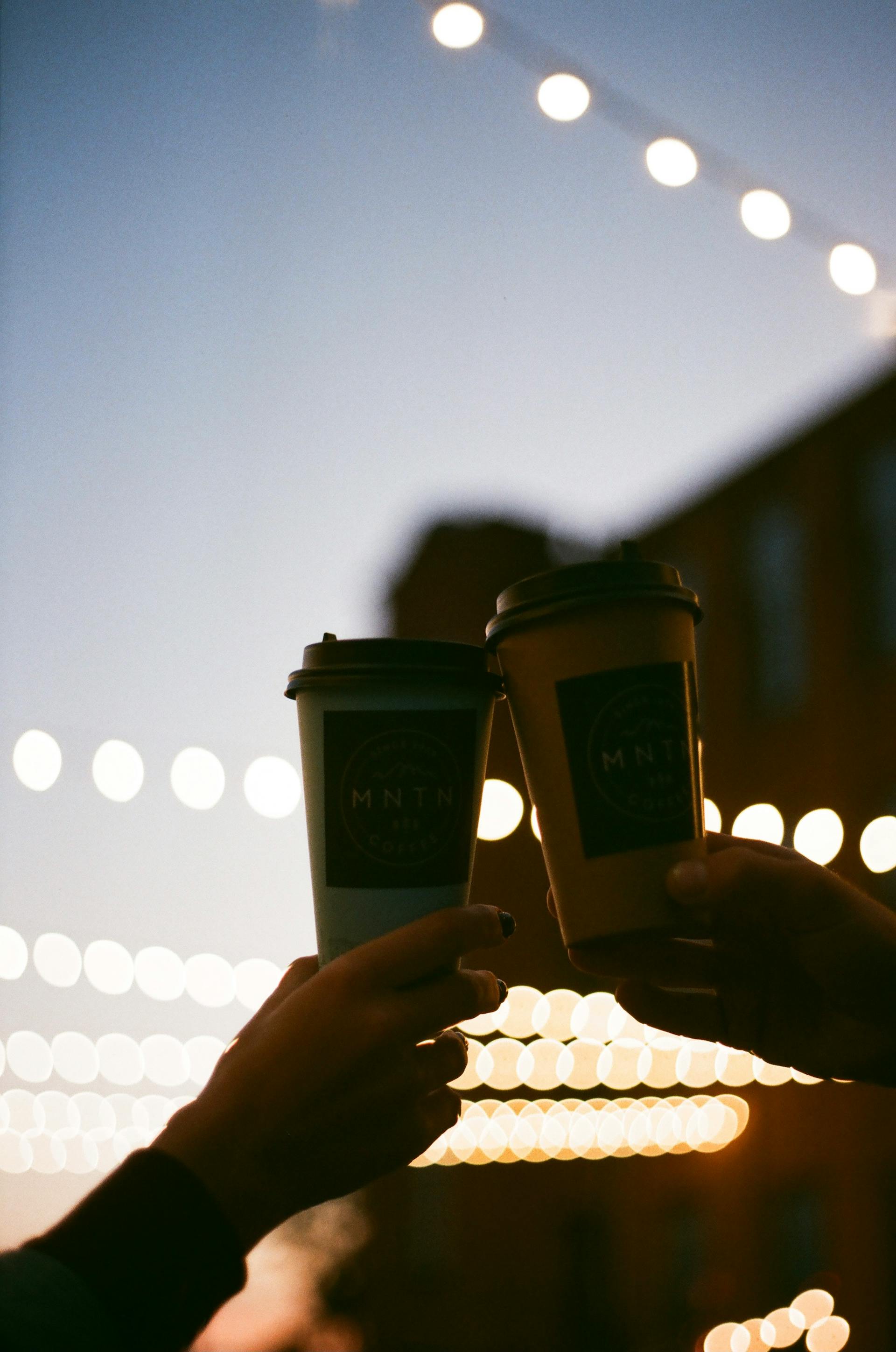 Dos manos sosteniendo tazas de café | Fuente: Pexels
