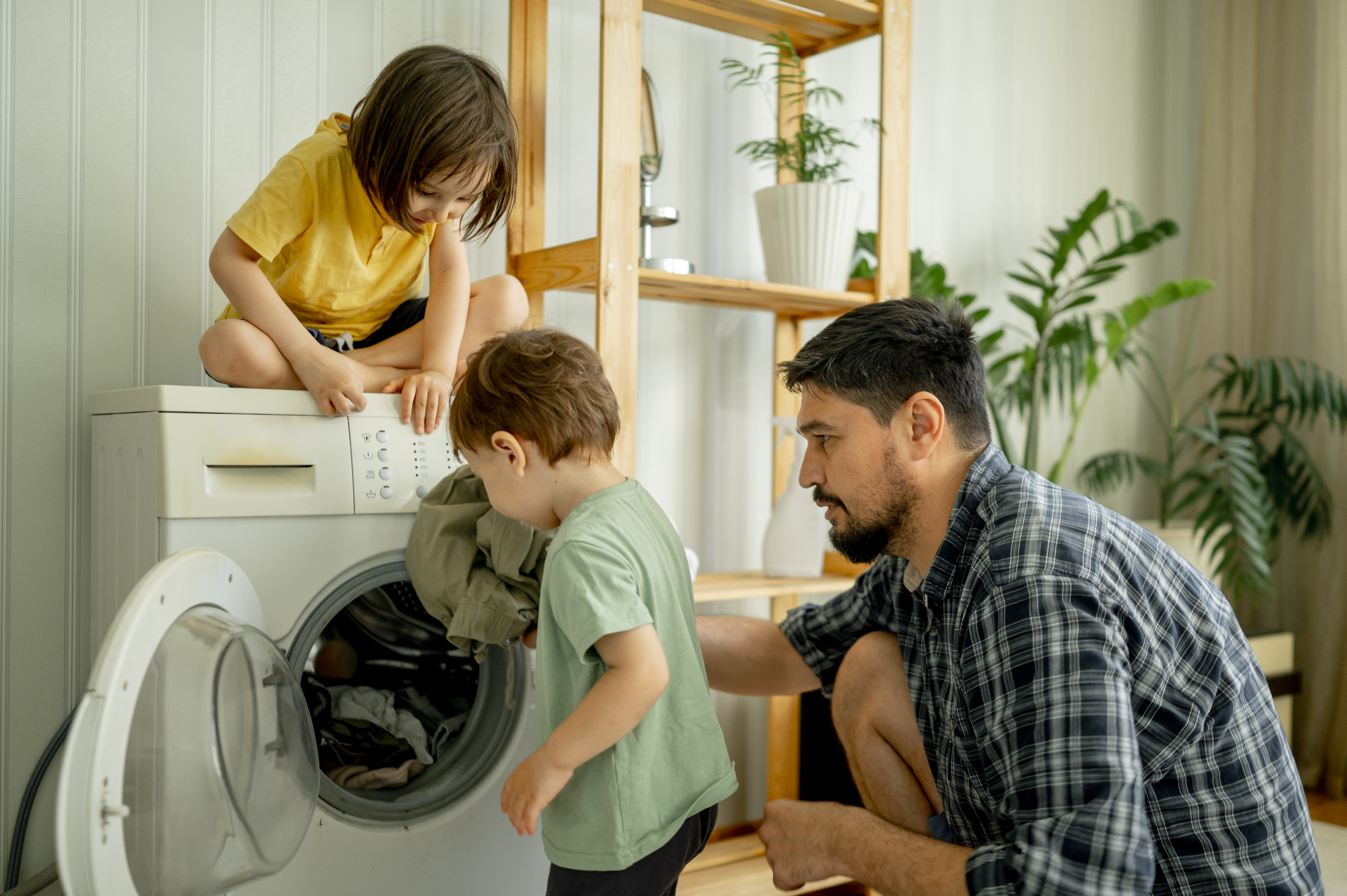 Padre e hijos cargando la lavadora | Foto: Getty Images