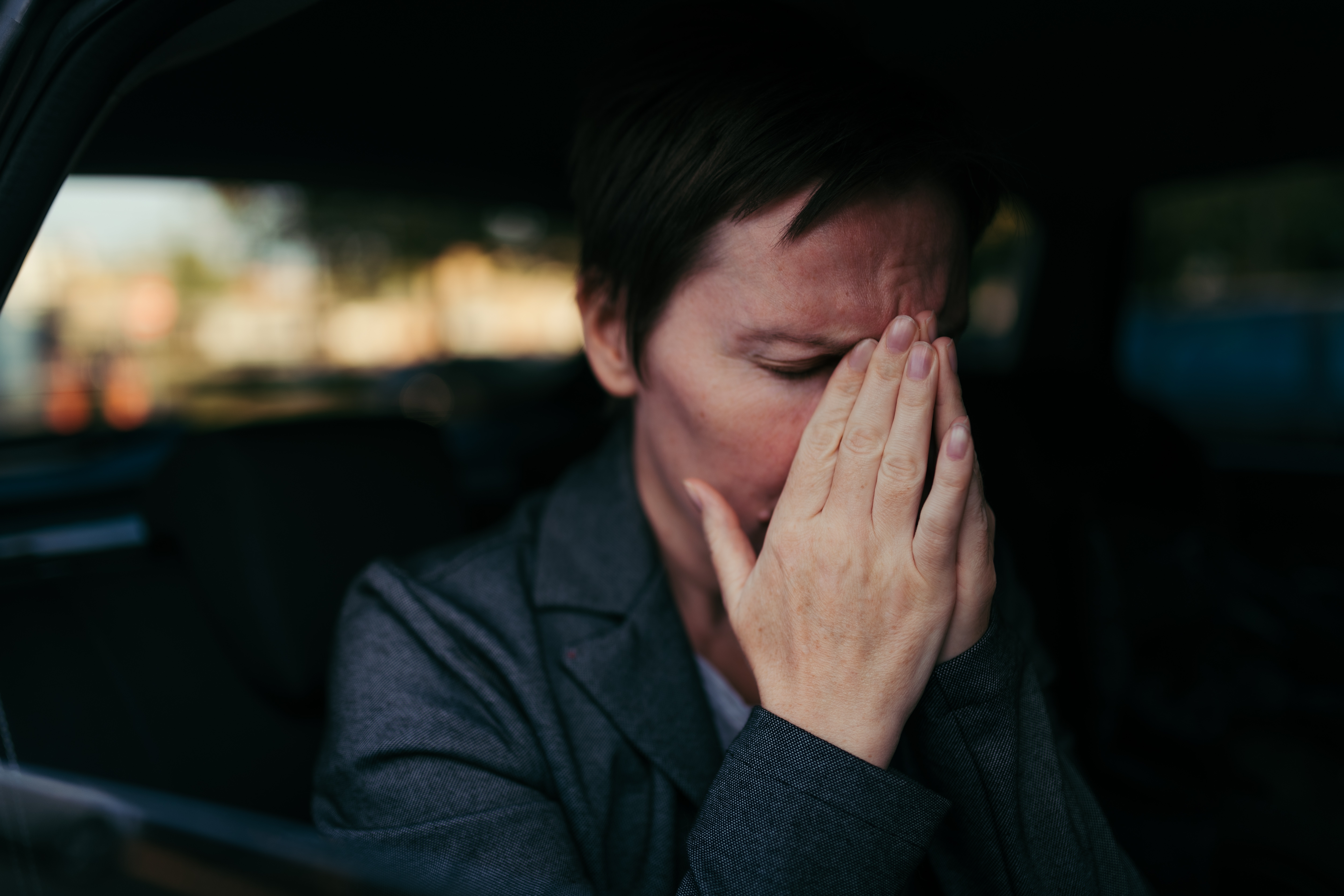 Una mujer ansiosa sentada en la parte trasera de un Automóvil | Foto: Shutterstock