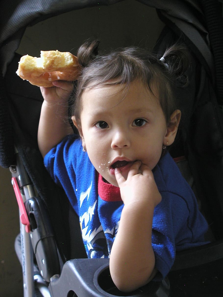 Imagen referencial. Niña sin hogar comiendo un trozo de pan sobre su cochecito. | Foto: PxFuel