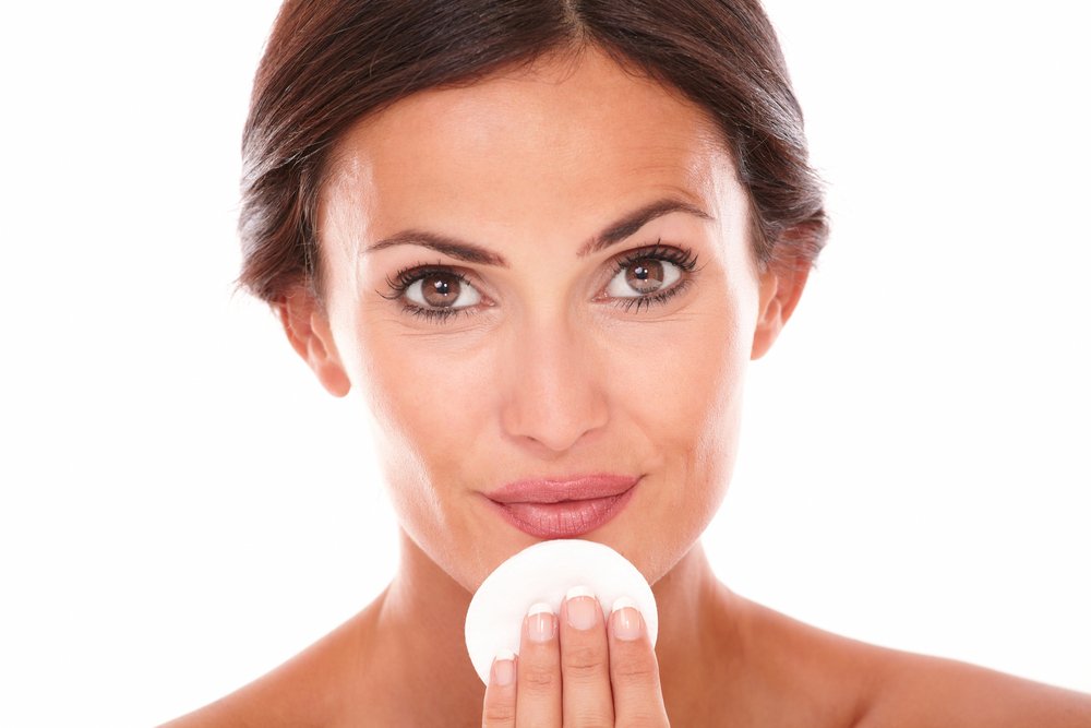 Mujer aplicándose productos de cuidado facial con algodón. | Foto: Shutterstock