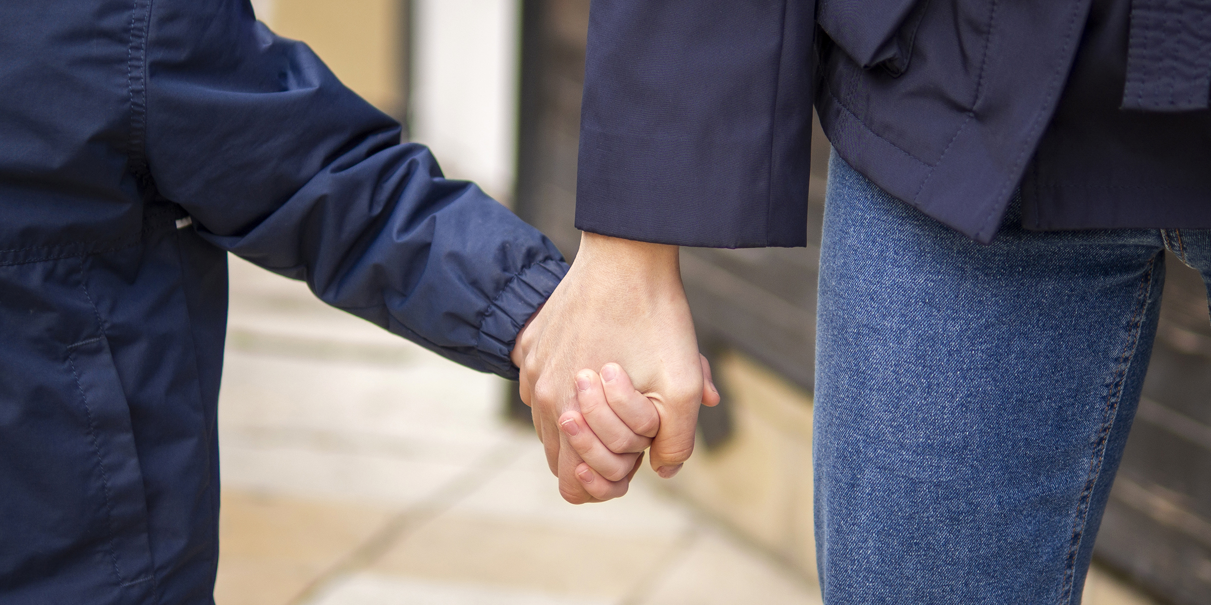 Una persona cogiendo de la mano a un niño | Fuente: Freepik