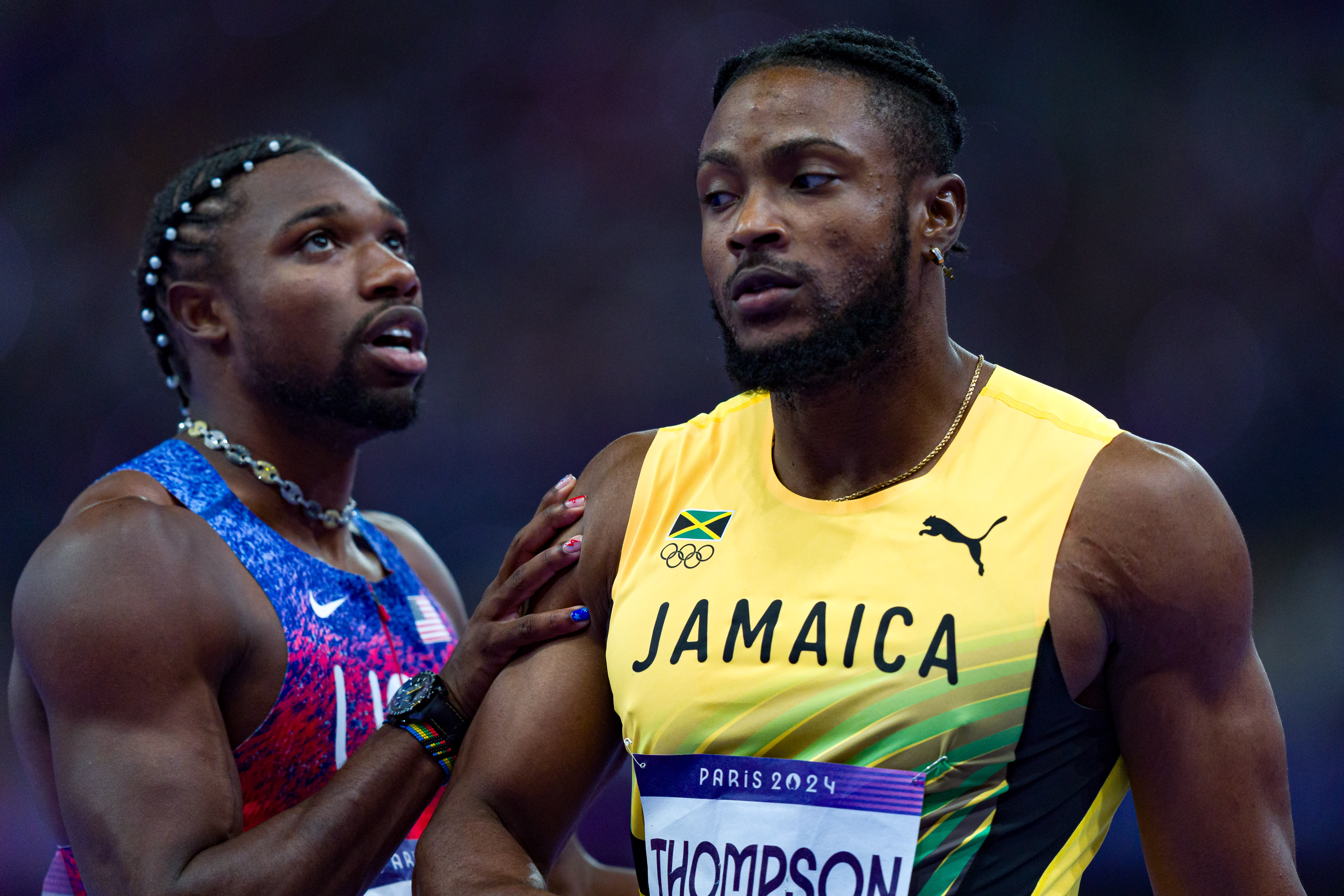 Noah Lyles y Kishane Thompson reaccionan mientras esperan los resultados de la competición durante la final masculina de los 100 metros planos de la prueba de atletismo de los Juegos Olímpicos de París 2024 en Saint-Denis, París, el 4 de agosto de 2024 | Fuente: Getty Images