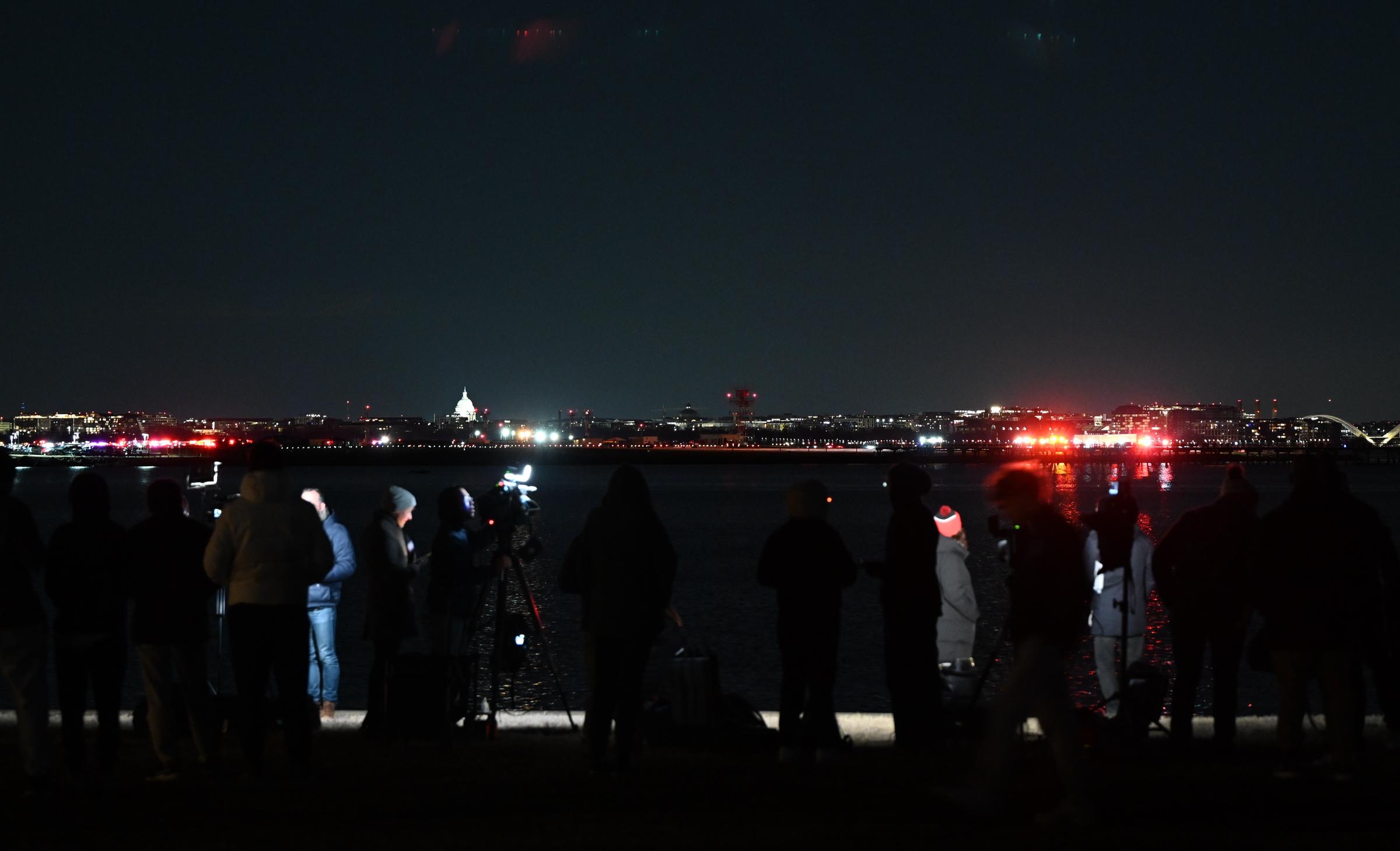 Miembros de la prensa trabajan cerca de la zona del siniestro después de que un avión regional colisionara en pleno vuelo con un helicóptero militar y se estrellara en el río Potomac en Washington, D.C., el 30 de enero de 2025 | Fuente: Getty Images