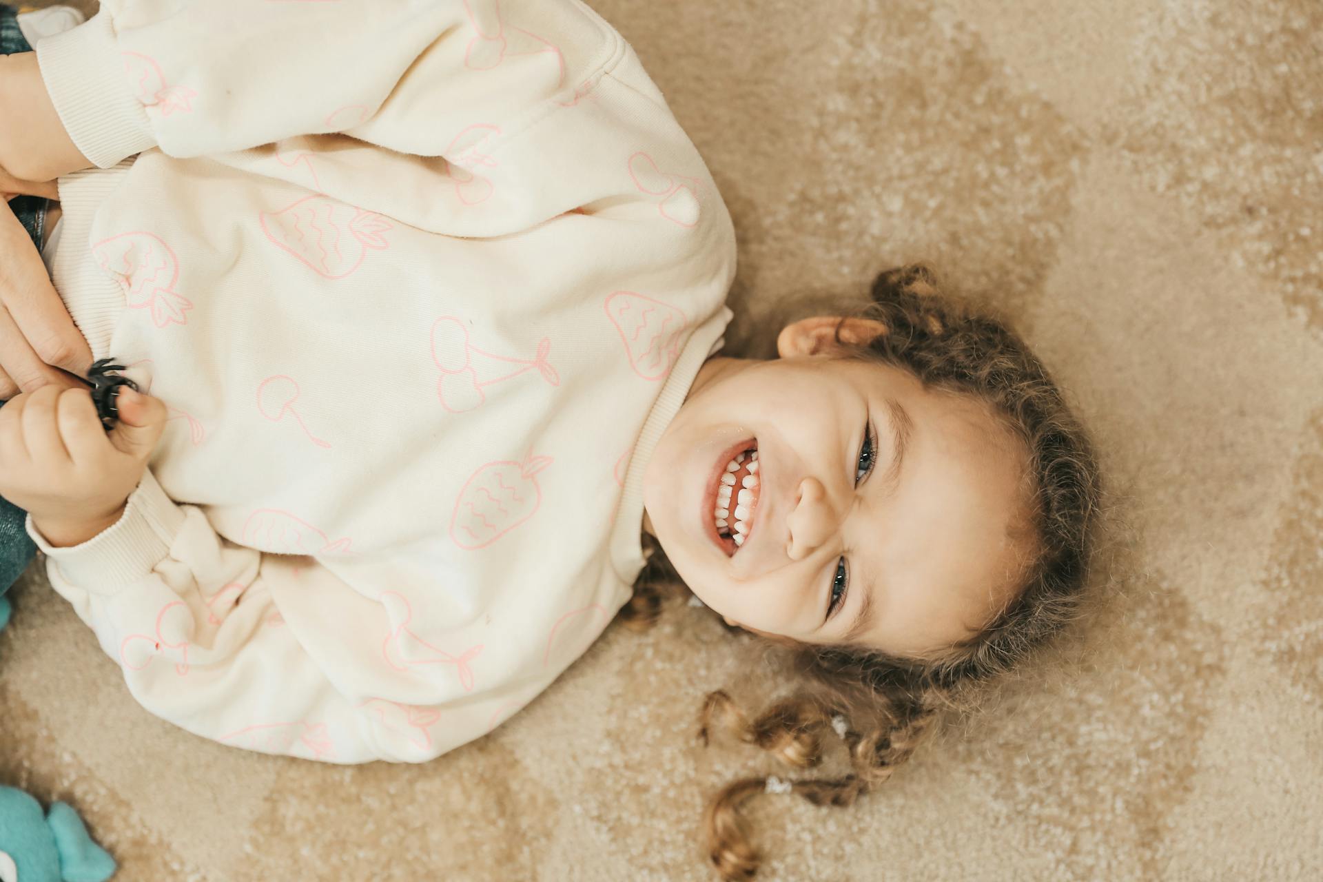 Un niño sonriente tumbado en el suelo | Foto: Pexels
