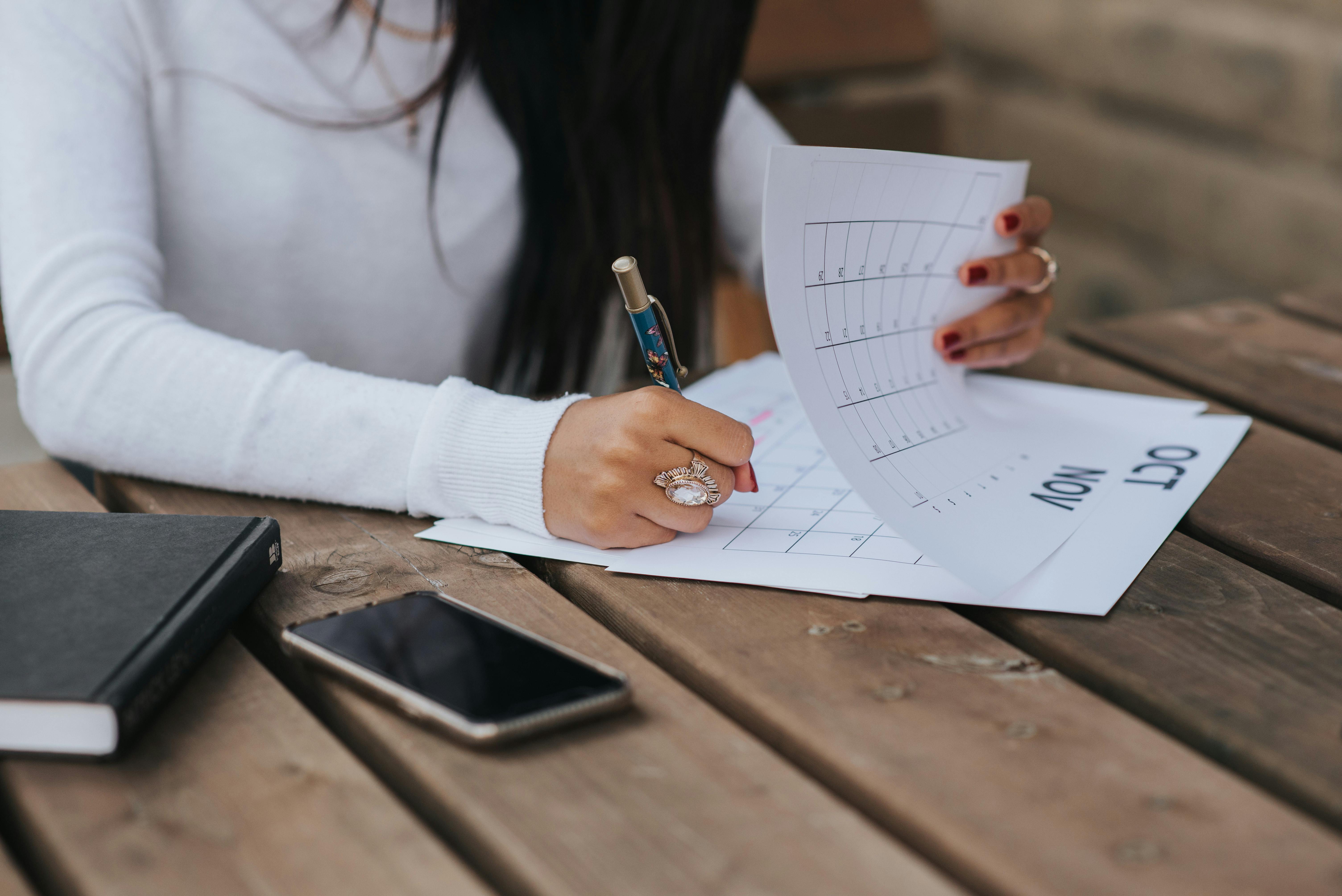 Una mujer tomando notas en un calendario | Fuente: Pexels