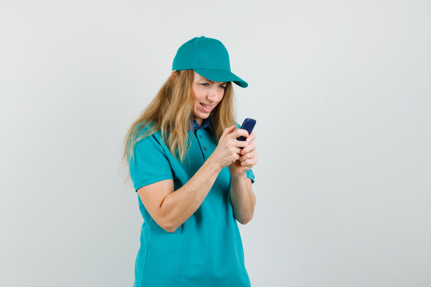Una mujer sonriente escribiendo mensajes en su teléfono | Fuente: Freepik