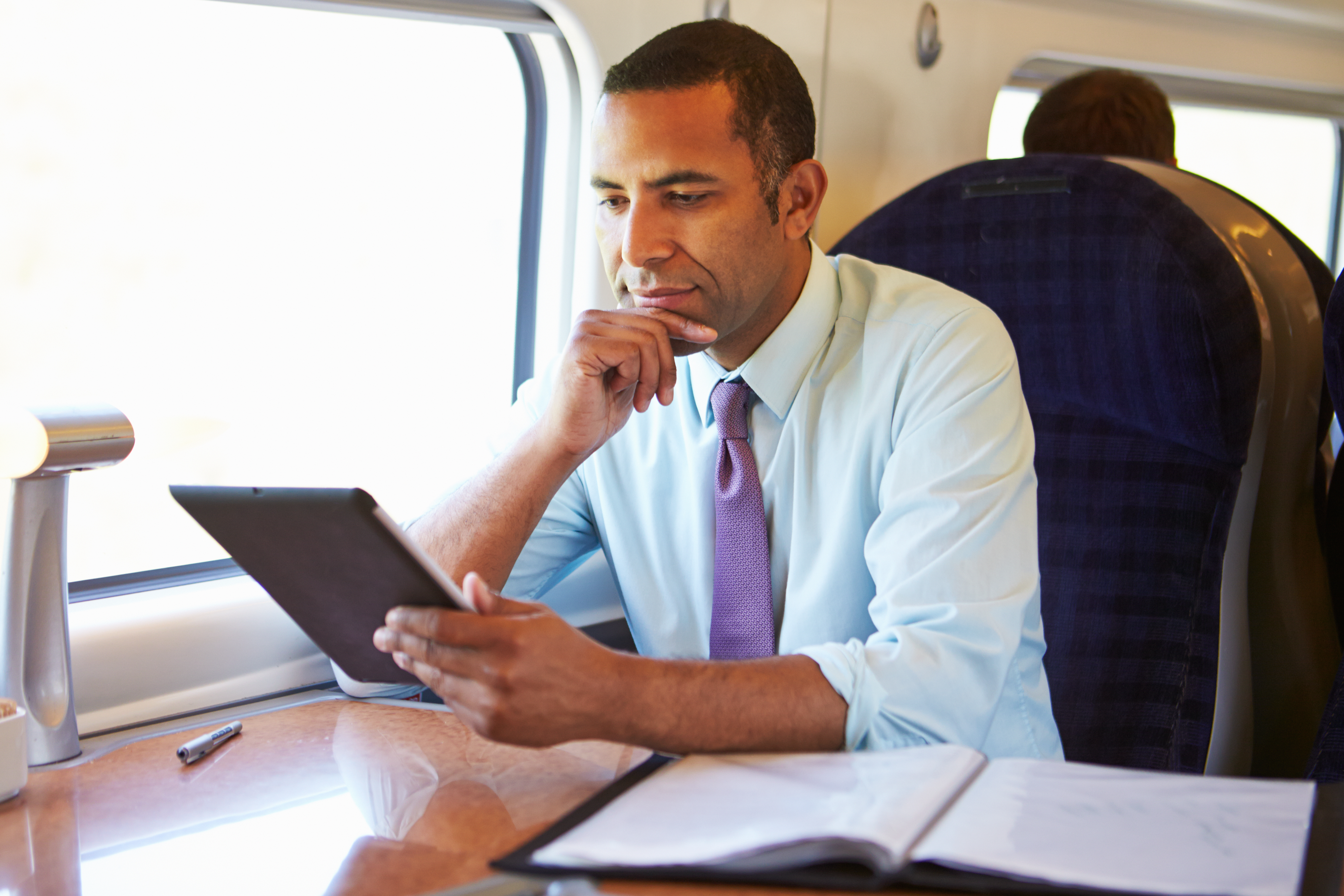 Un hombre sentado en el asiento de la ventanilla de un tren | Foto: Shutterstock