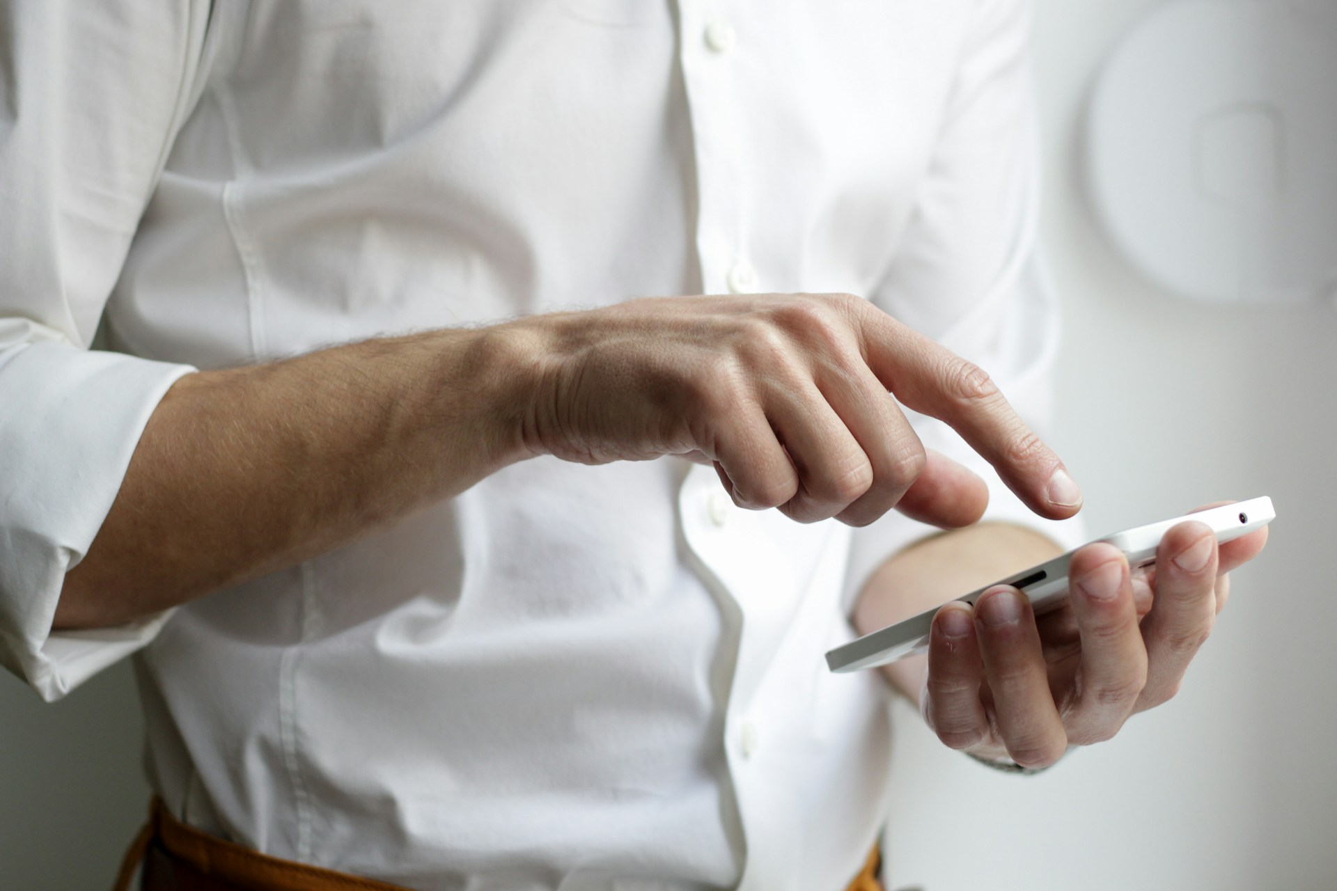 Primer plano recortado de un hombre sujetando su teléfono | Fuente: Unsplash