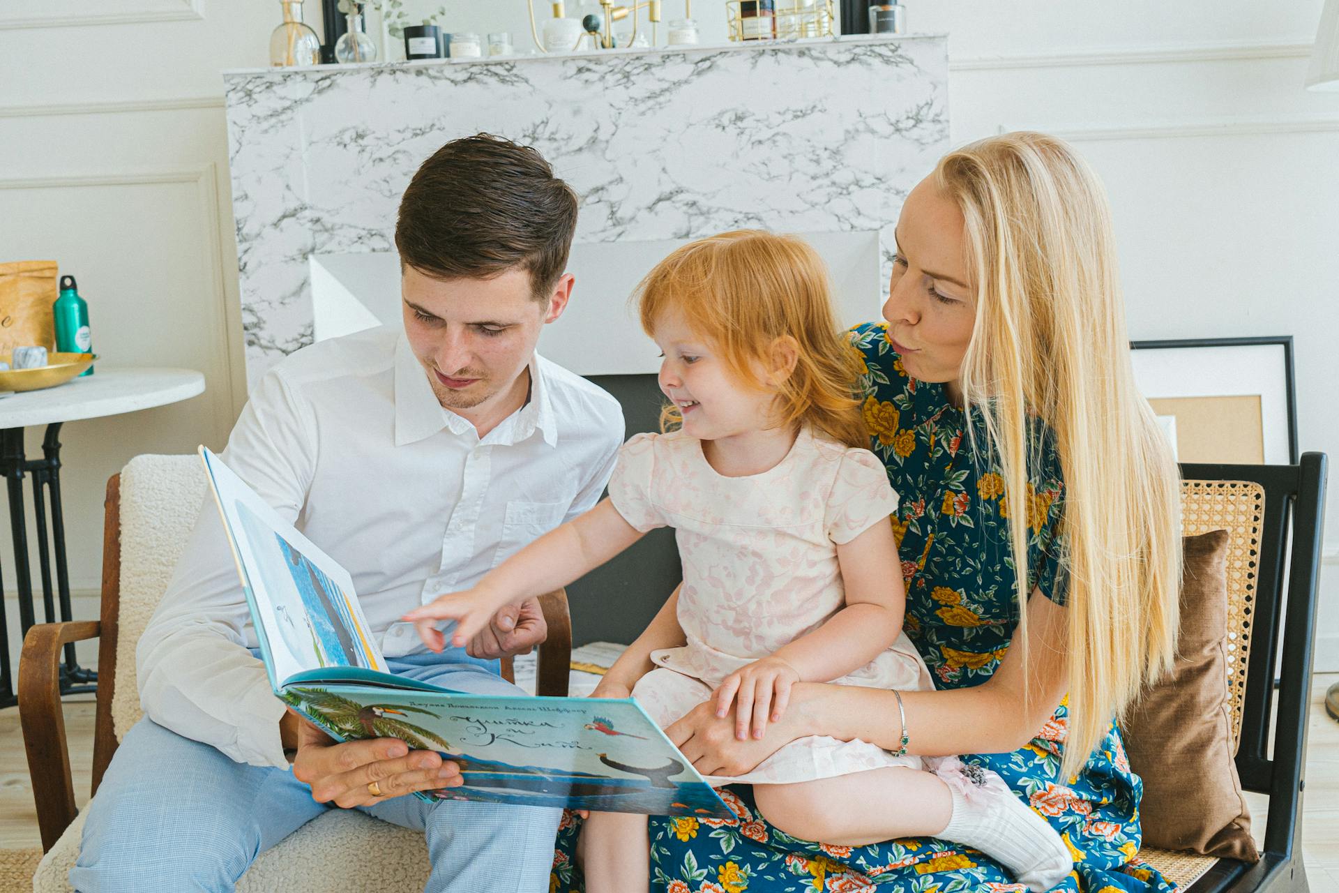 Unos padres leyendo un libro a su hija pequeña | Fuente: Pexels