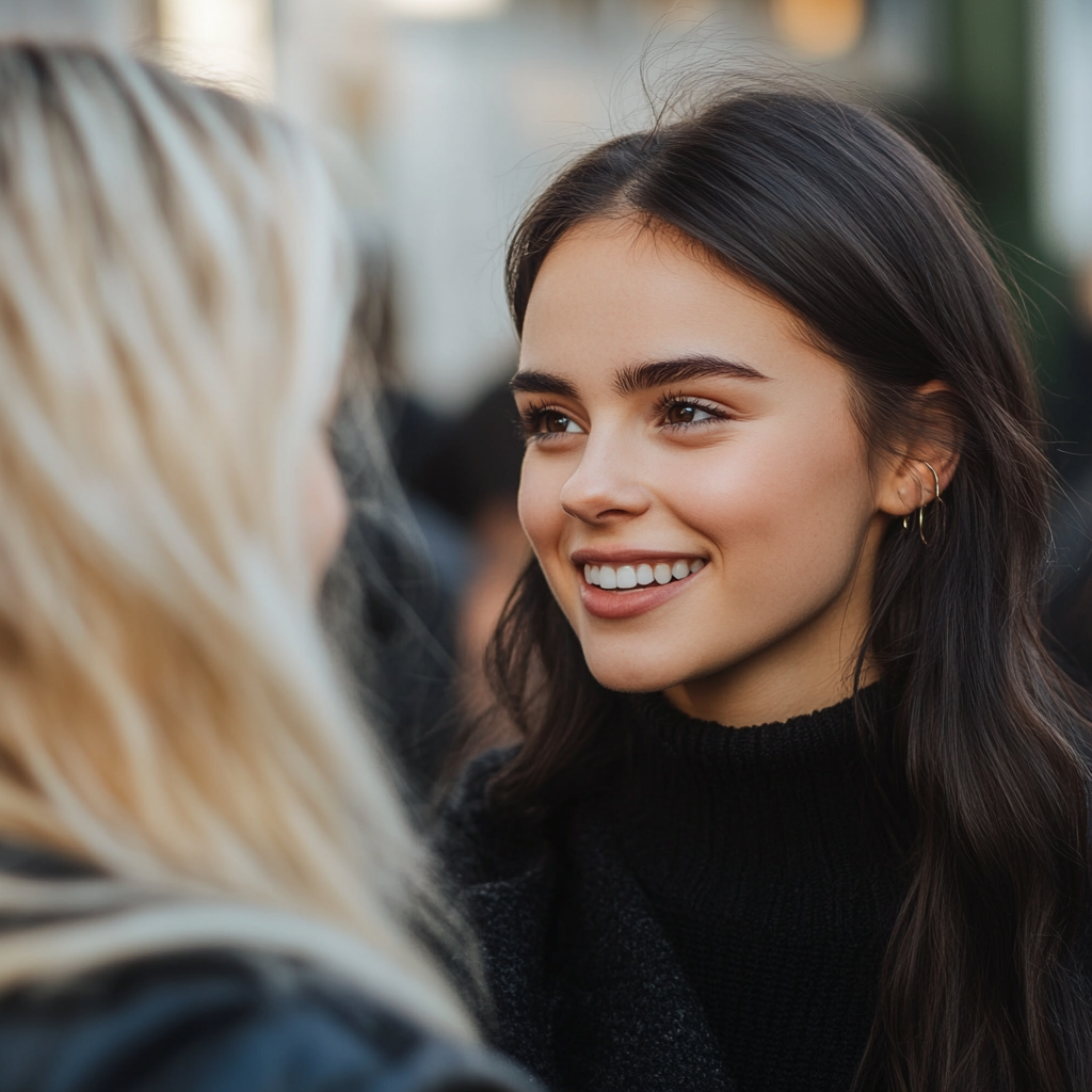 Una mujer sonriente hablando con su amiga | Fuente: Midjourney