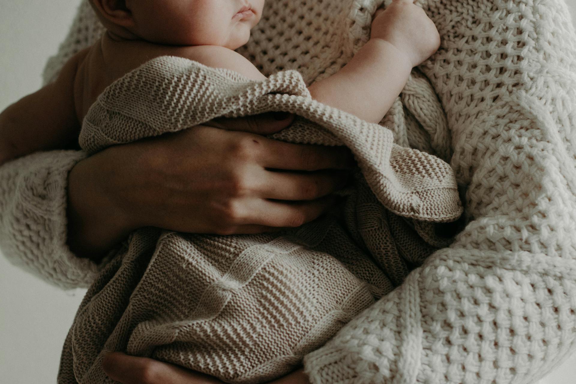 Persona con un bebé en brazos | Foto: Pexels