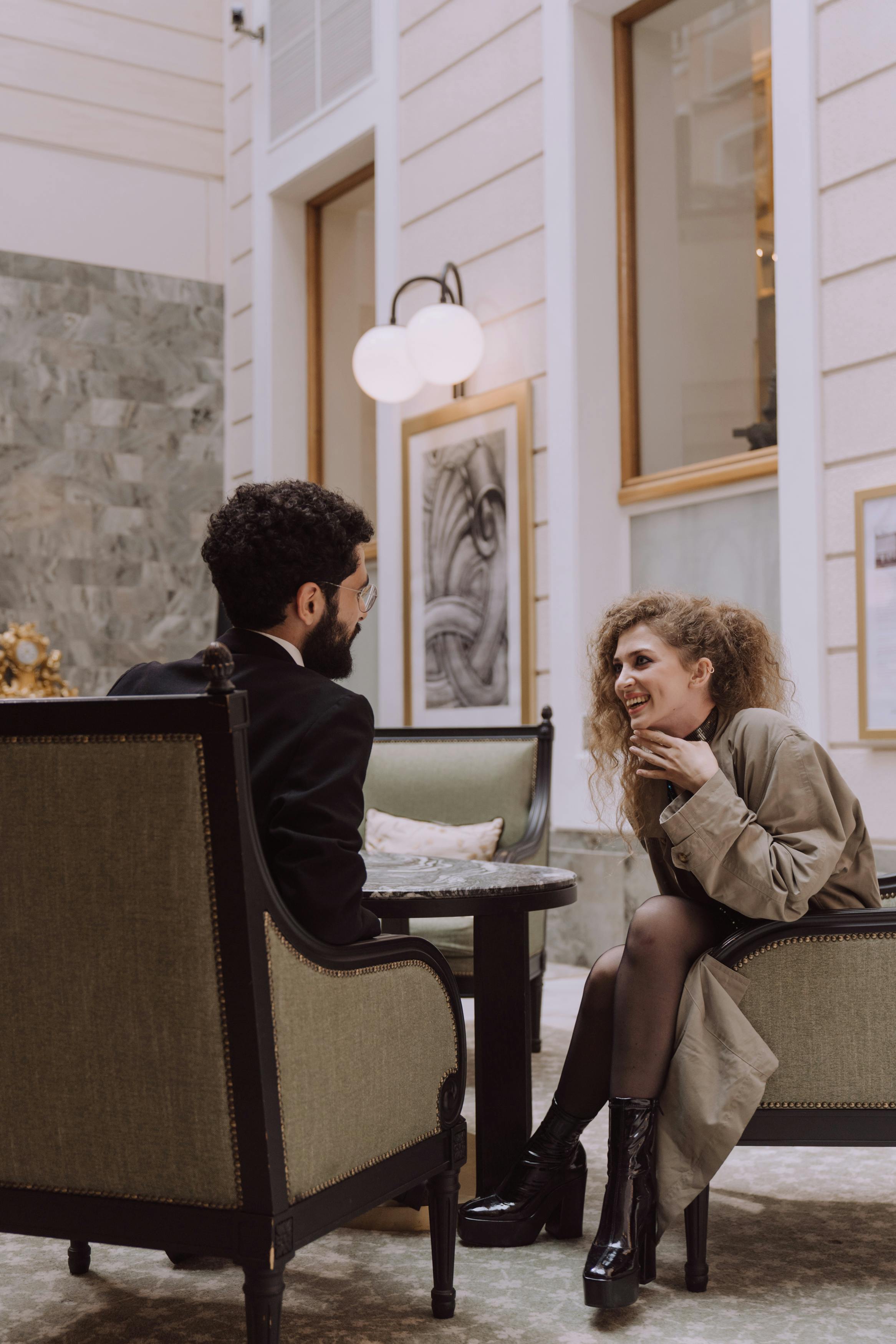 Una mujer riendo mientras habla con un hombre | Foto: Pexels