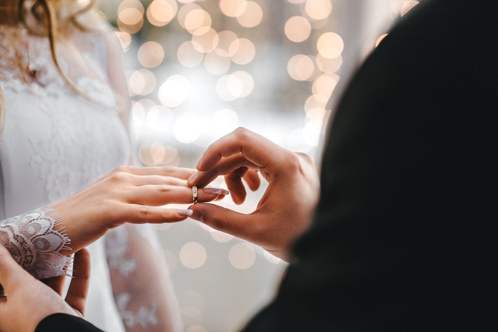 Novio colocando el anillo de matrimonio a la novia durante su boda. | Foto: Shutterstock