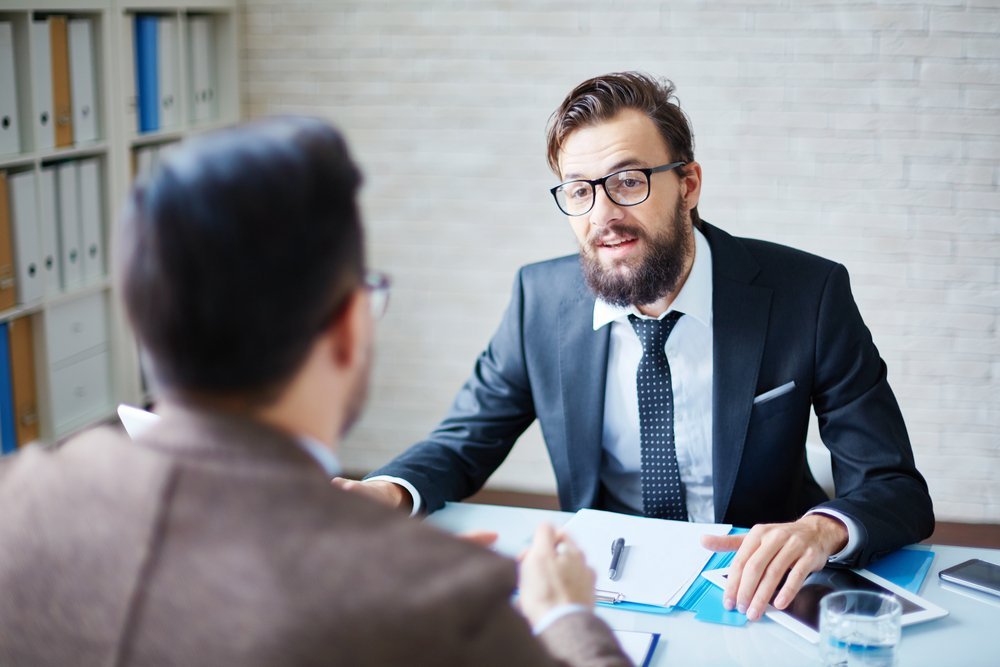 Un jefe hablando con un empleado en la oficina. | Foto: Shutterstock