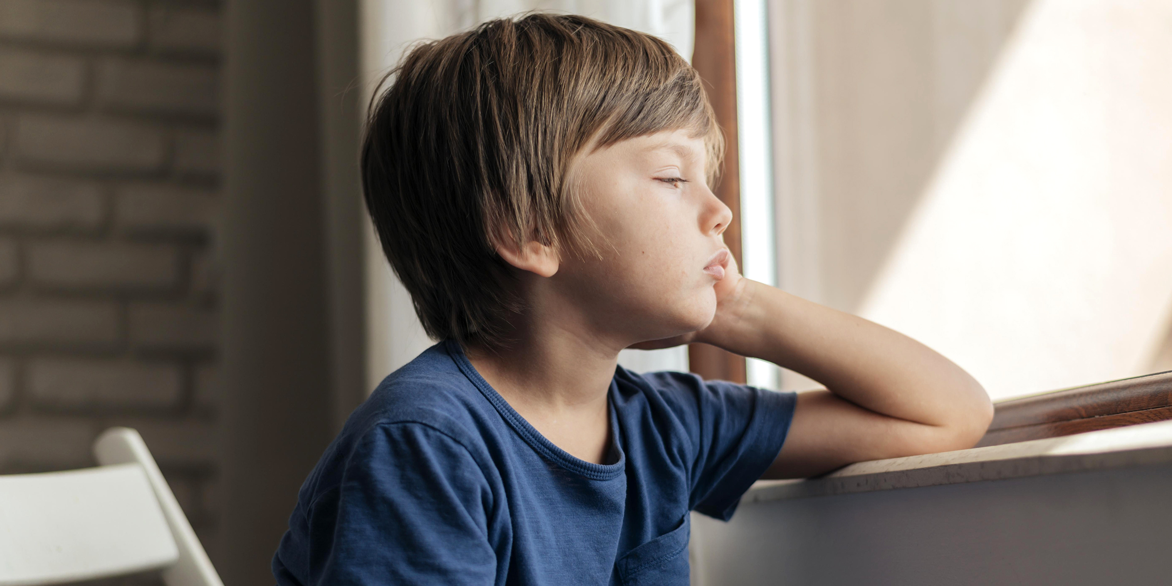 Un niño huraño mirando por la ventana | Fuente: Freepik