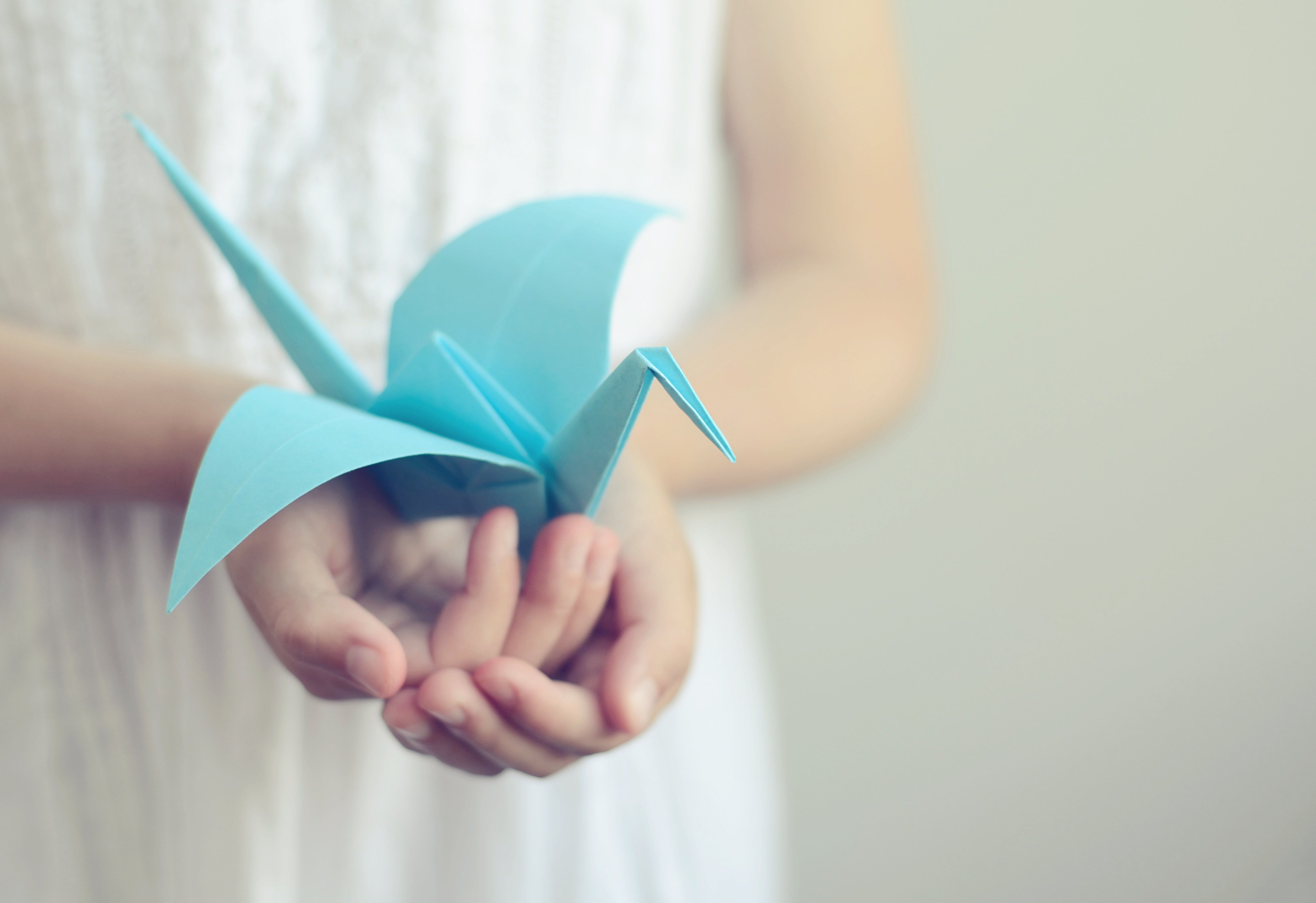 Niña pequeña con origami de grulla en las manos. | Foto: Shutterstock