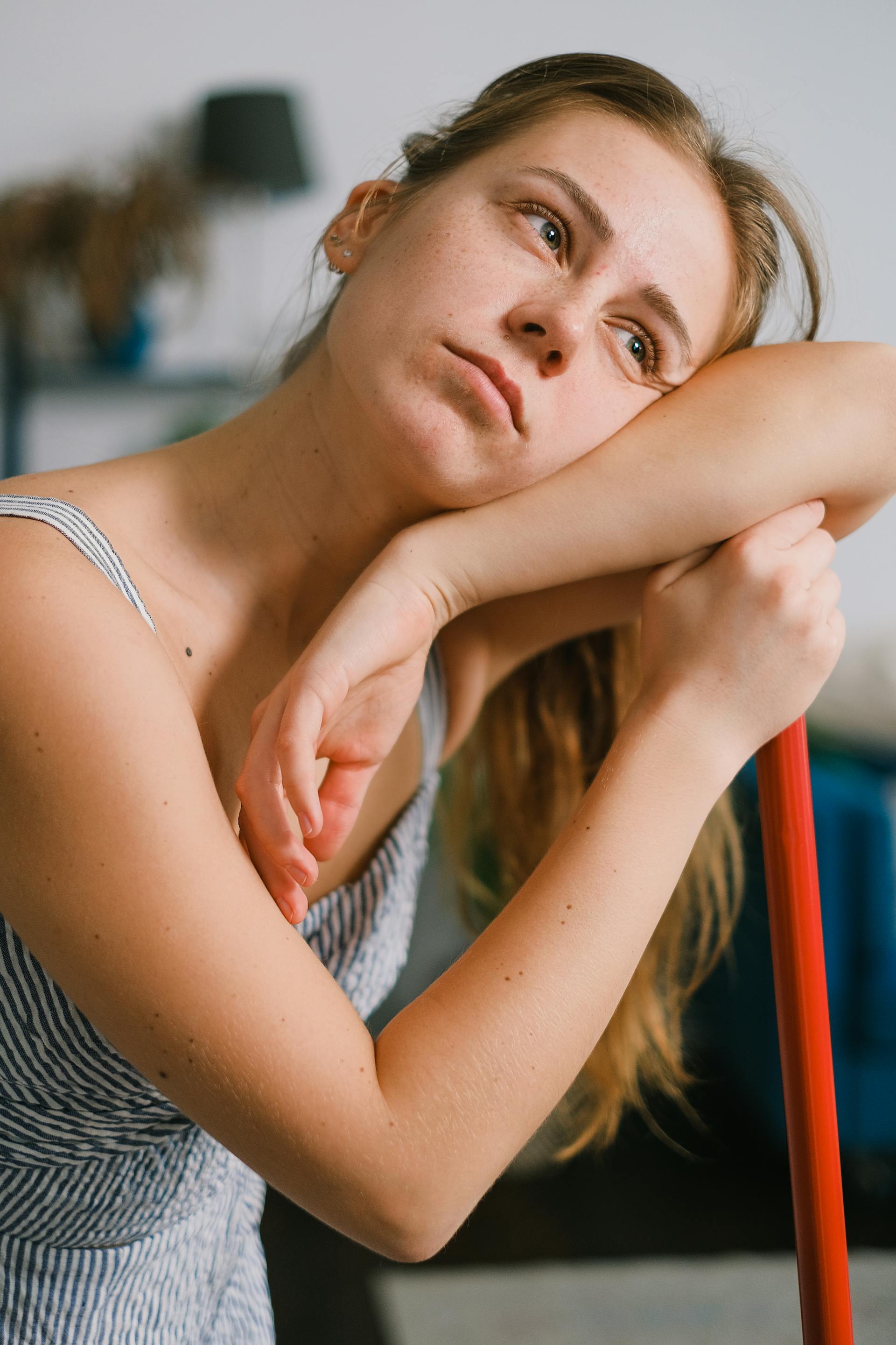 Una mujer cansada apoyada en una fregona mientras limpia | Fuente: Pexels