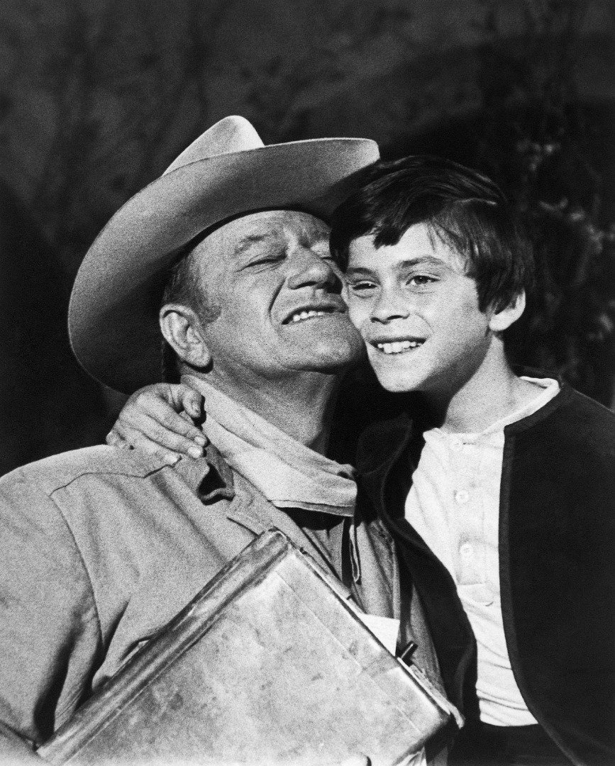 John Ethan Wayne, comparte un abrazo con su papá, John Wayne, tras rodar una escena de "The Million Dollar Kidnapping" | Foto: Getty Images