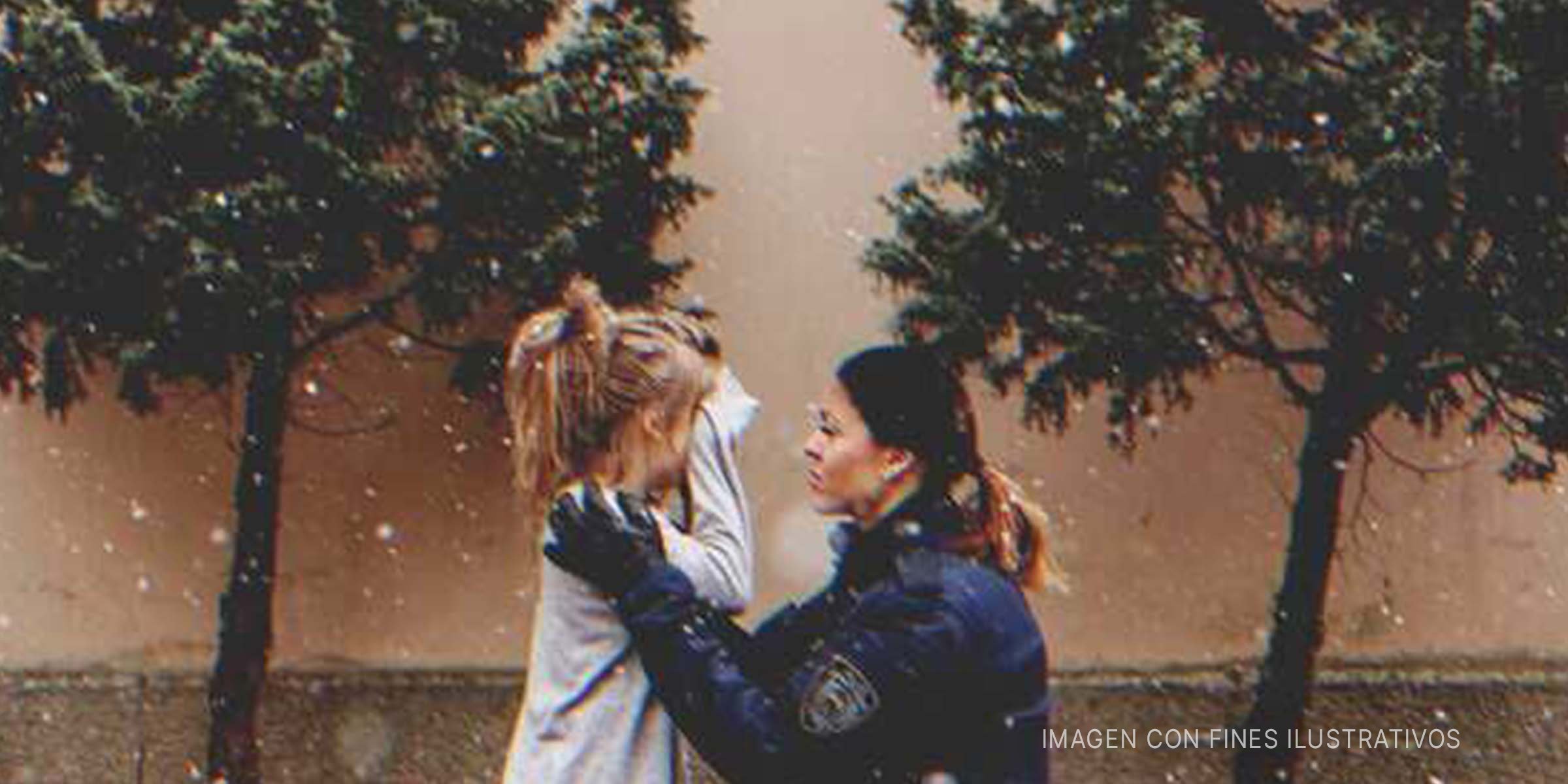 Mujer policía consolando a una niña triste | Foto: Getty Images | Shutterstock