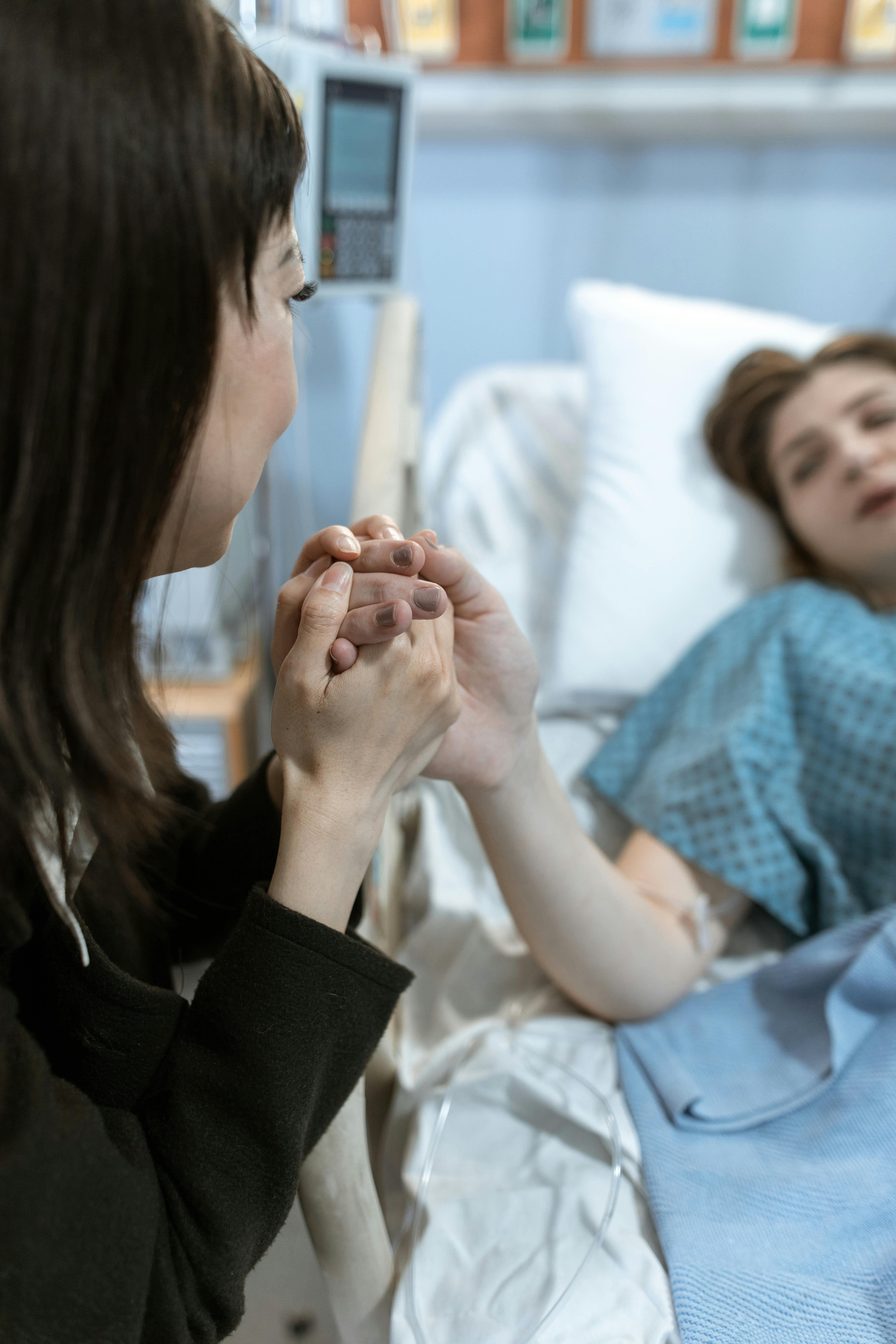 Mujer tomando la mano de una enferma | Foto: Pexels