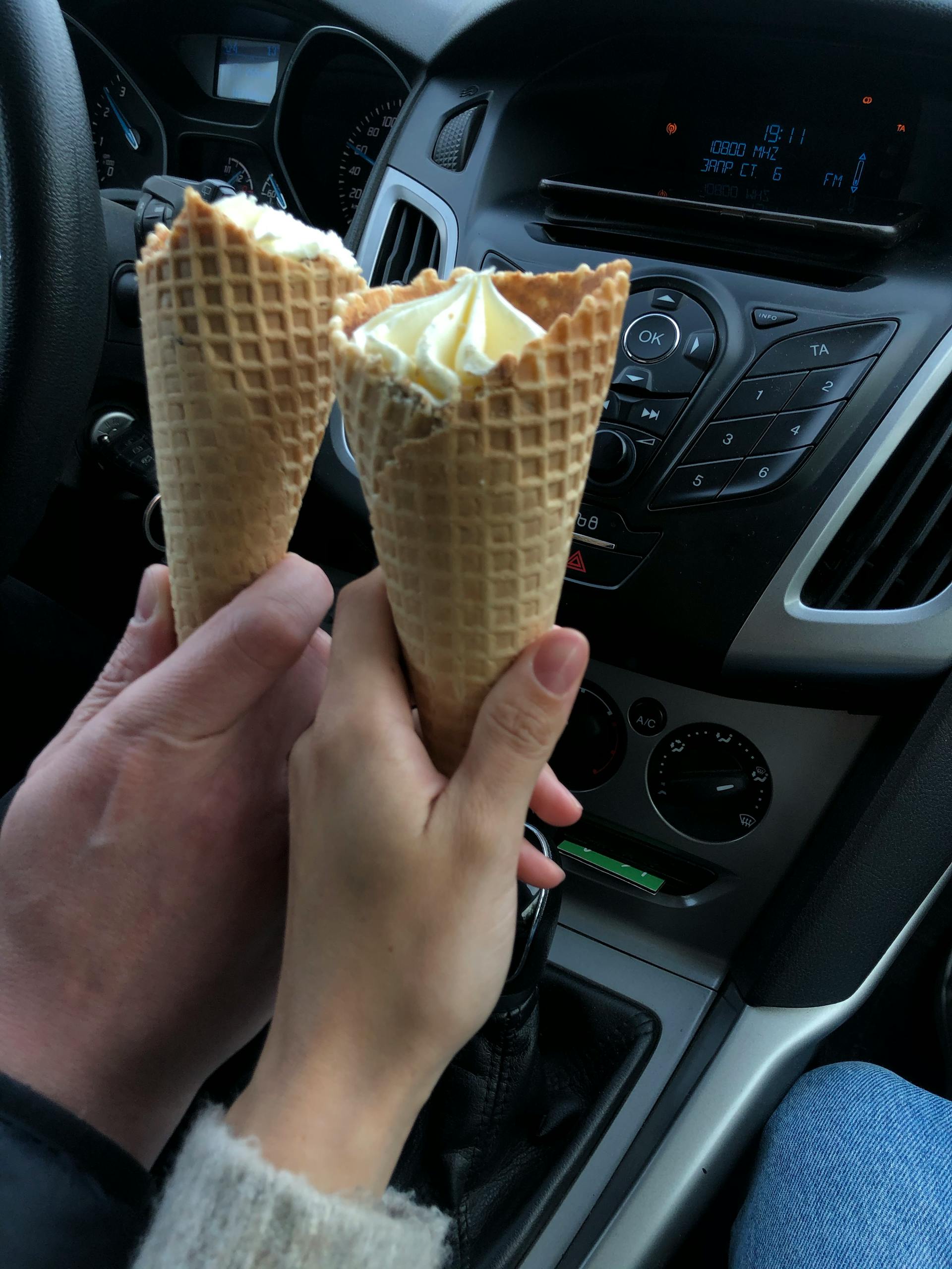 Una coppia che tiene in mano dei coni gelato in un'auto | Fonte: Pexels