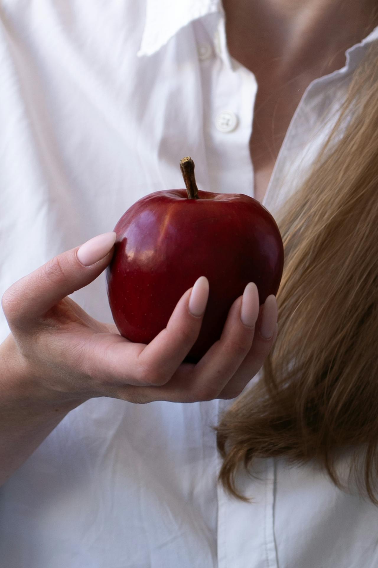 Una mujer sosteniendo una manzana | Fuente: Pexels