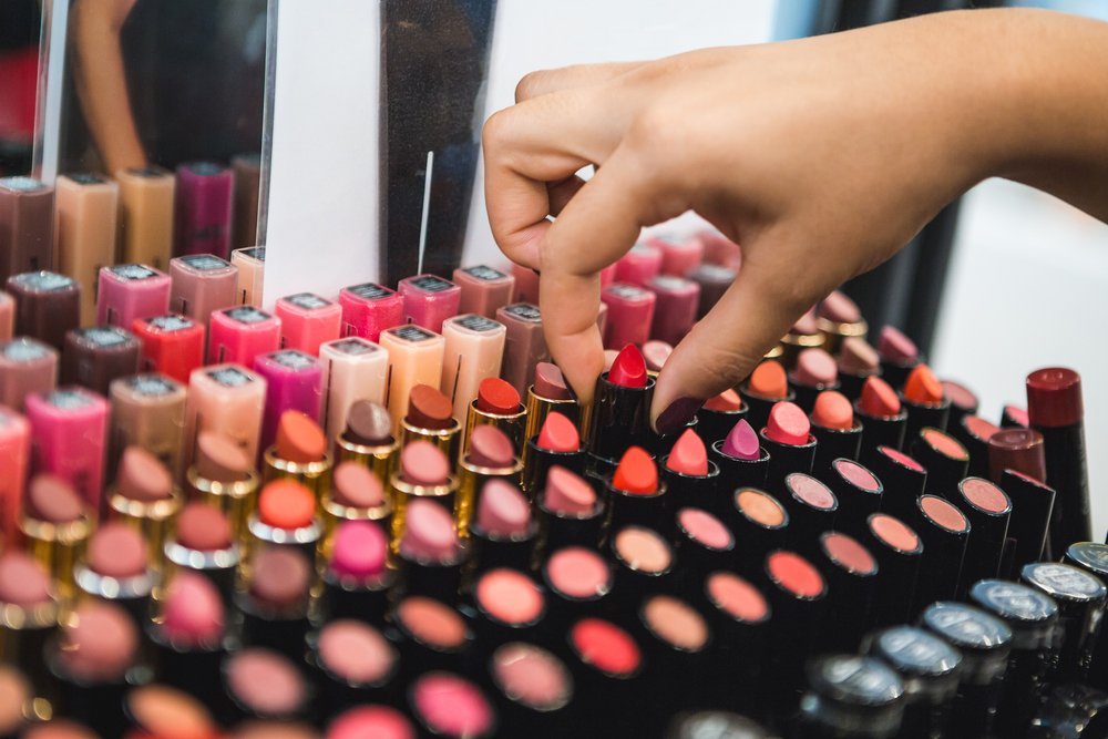 Mujer escogiendo labiales en una tienda de maquillaje. | Foto: Shutterstock
