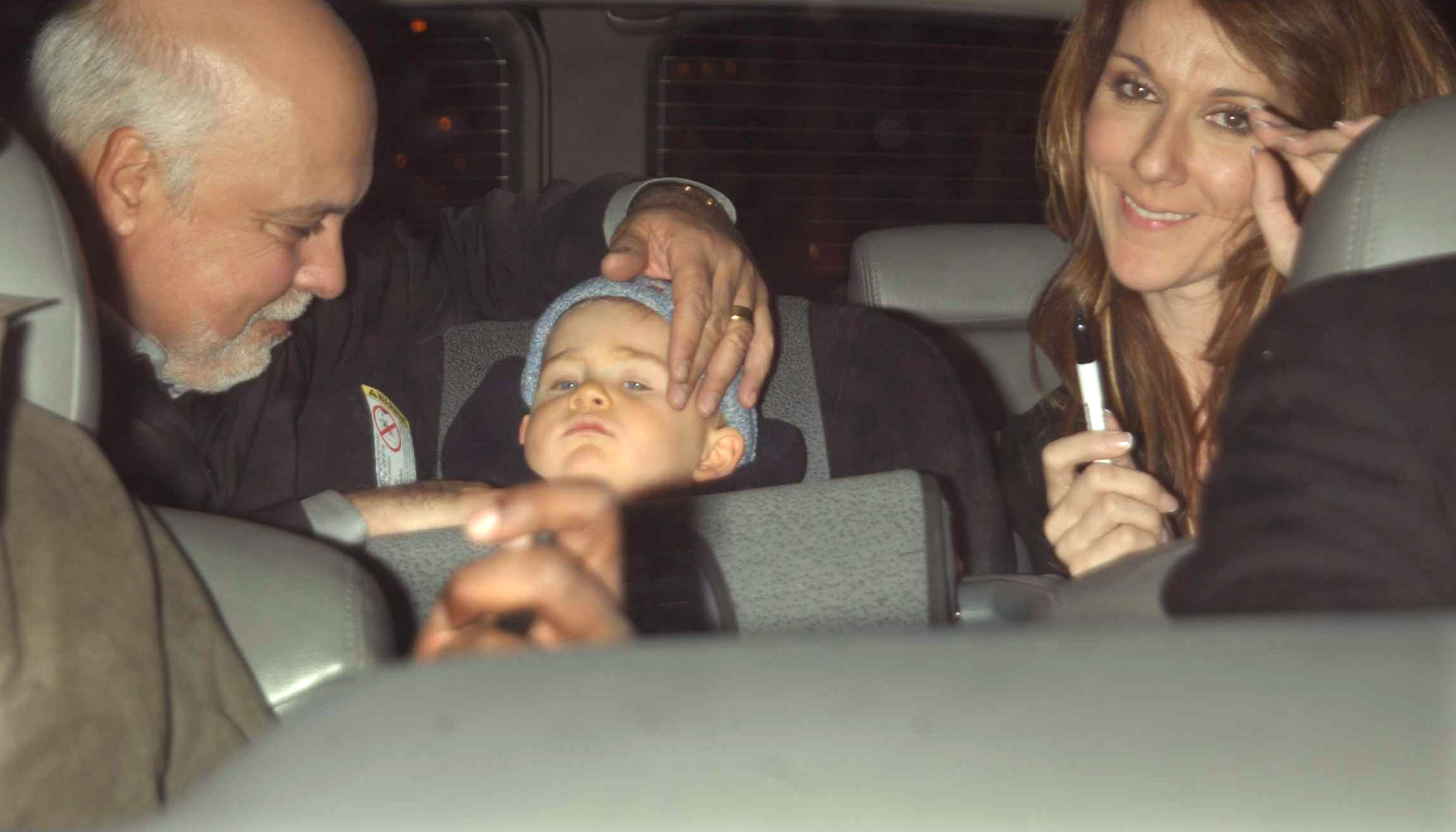 René Angélil, René-Charles y Céline Dion fotografiados en el interior de un vehículo el 27 de marzo de 2002 en Nueva York. | Fuente: Getty Images