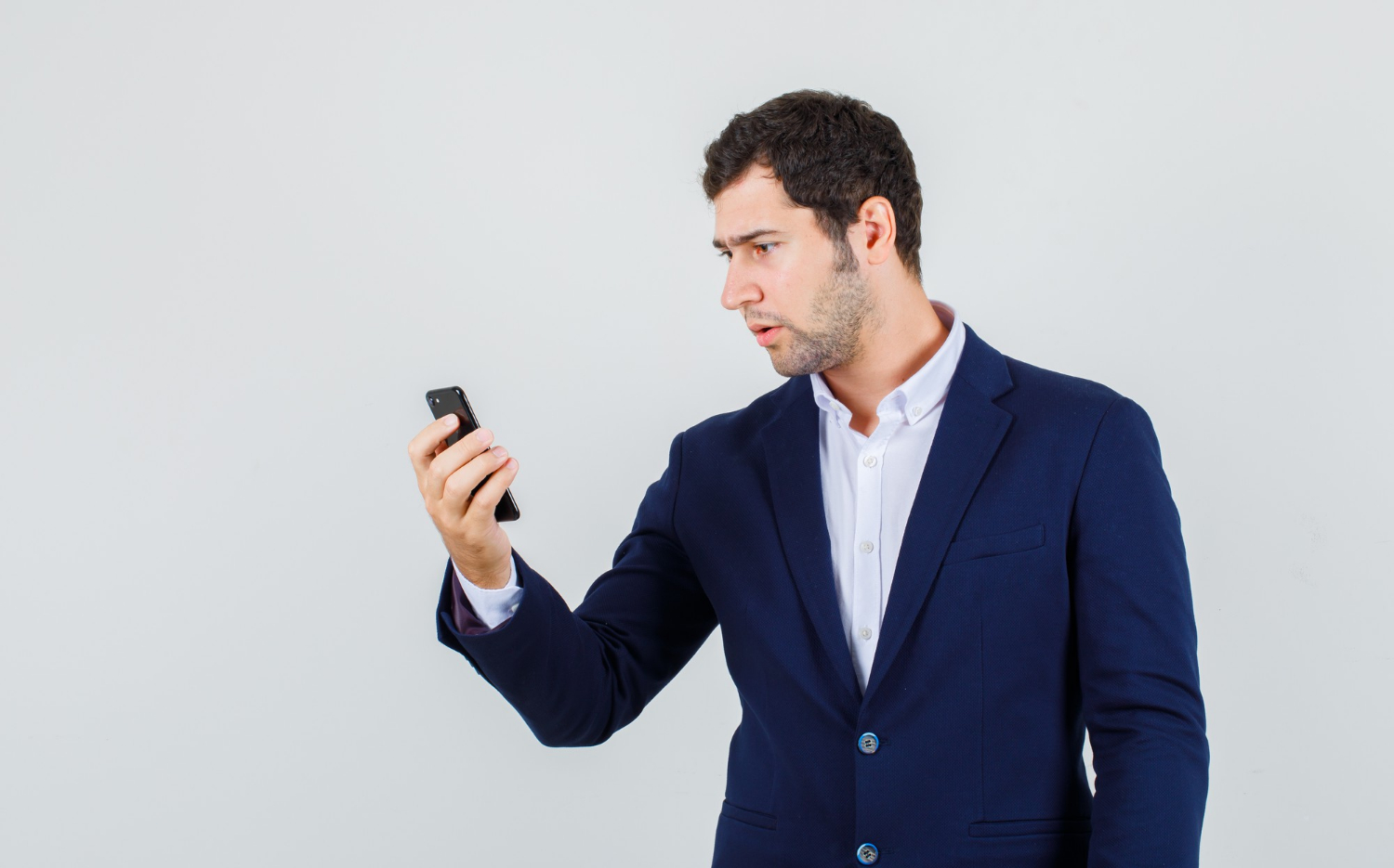 Un joven asustado mirando un teléfono | Fuente: Freepik