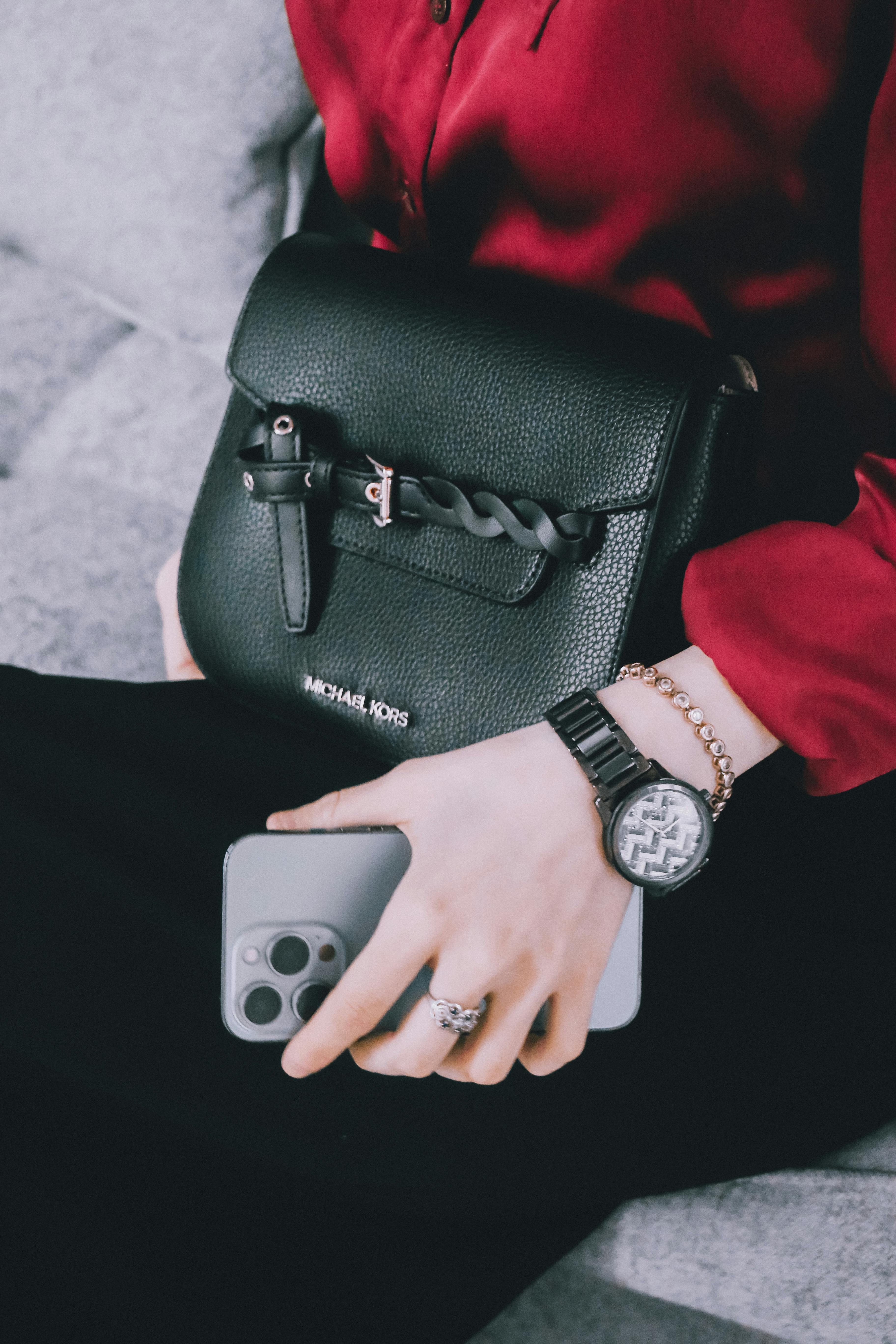 Una mujer con un reloj caro, joyas, teléfono y bolso | Foto: Pexels