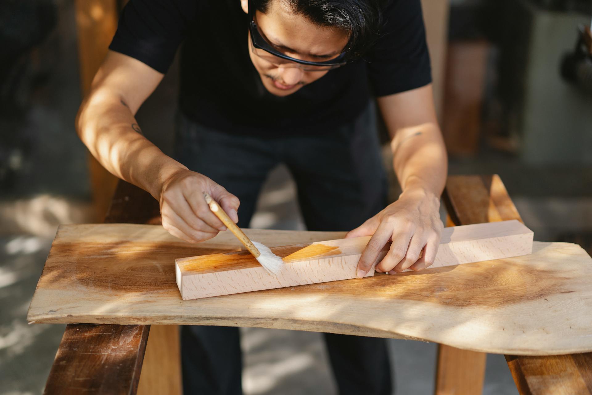 Un hombre utilizando barniz sobre madera | Fuente: Pexels