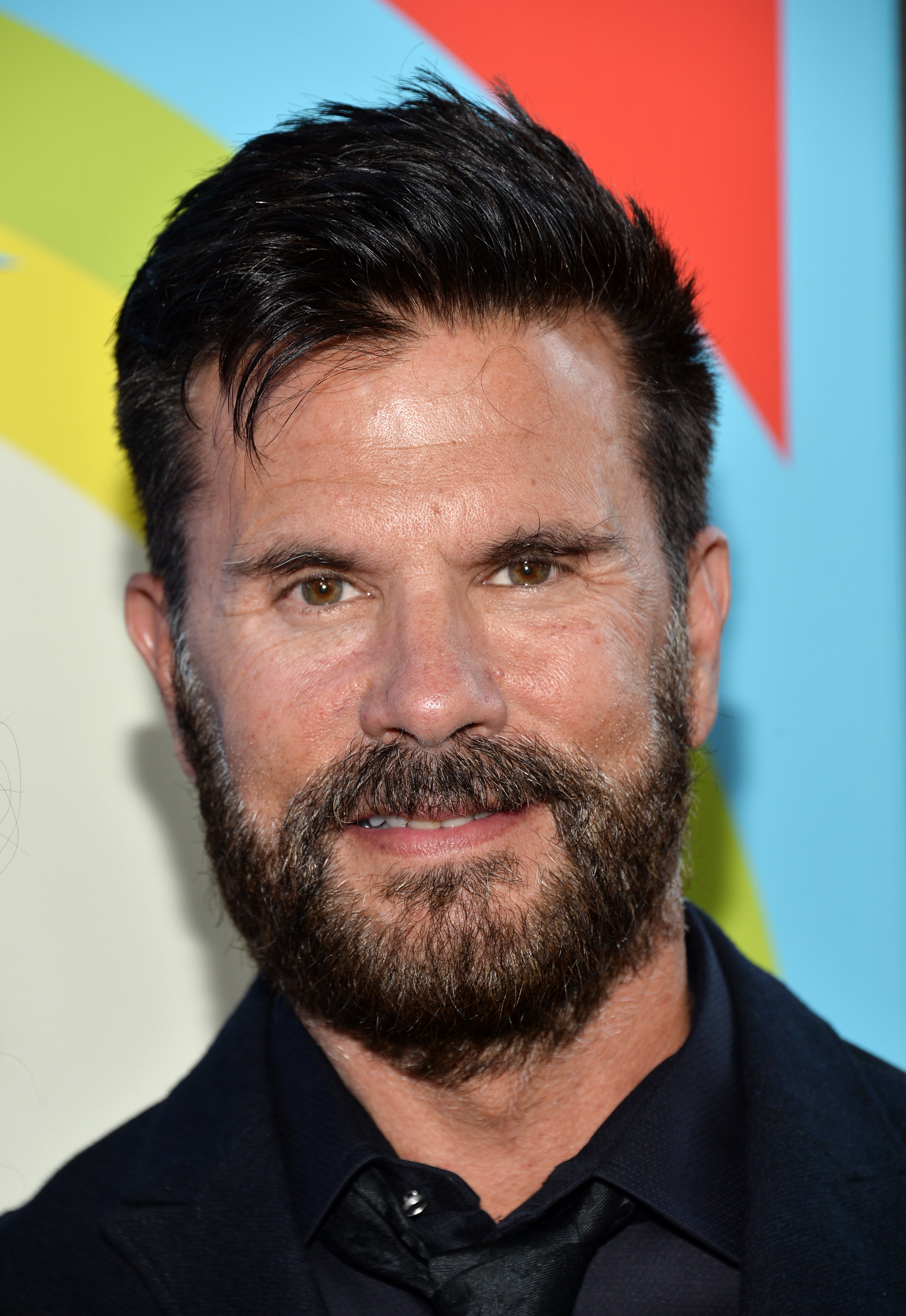 Lorenzo Lamas asiste al estreno de "Love & Mercy" en el Samuel Goldwyn Theater de Beverly Hills, California, el 2 de junio de 2015. Sonriendo a la cámara, el actor luce barba tupida entrecana, cabello oscuro corto y texturizado, camisa negra elegante, corbata a juego y saco entallado. | Fuente: Getty Images