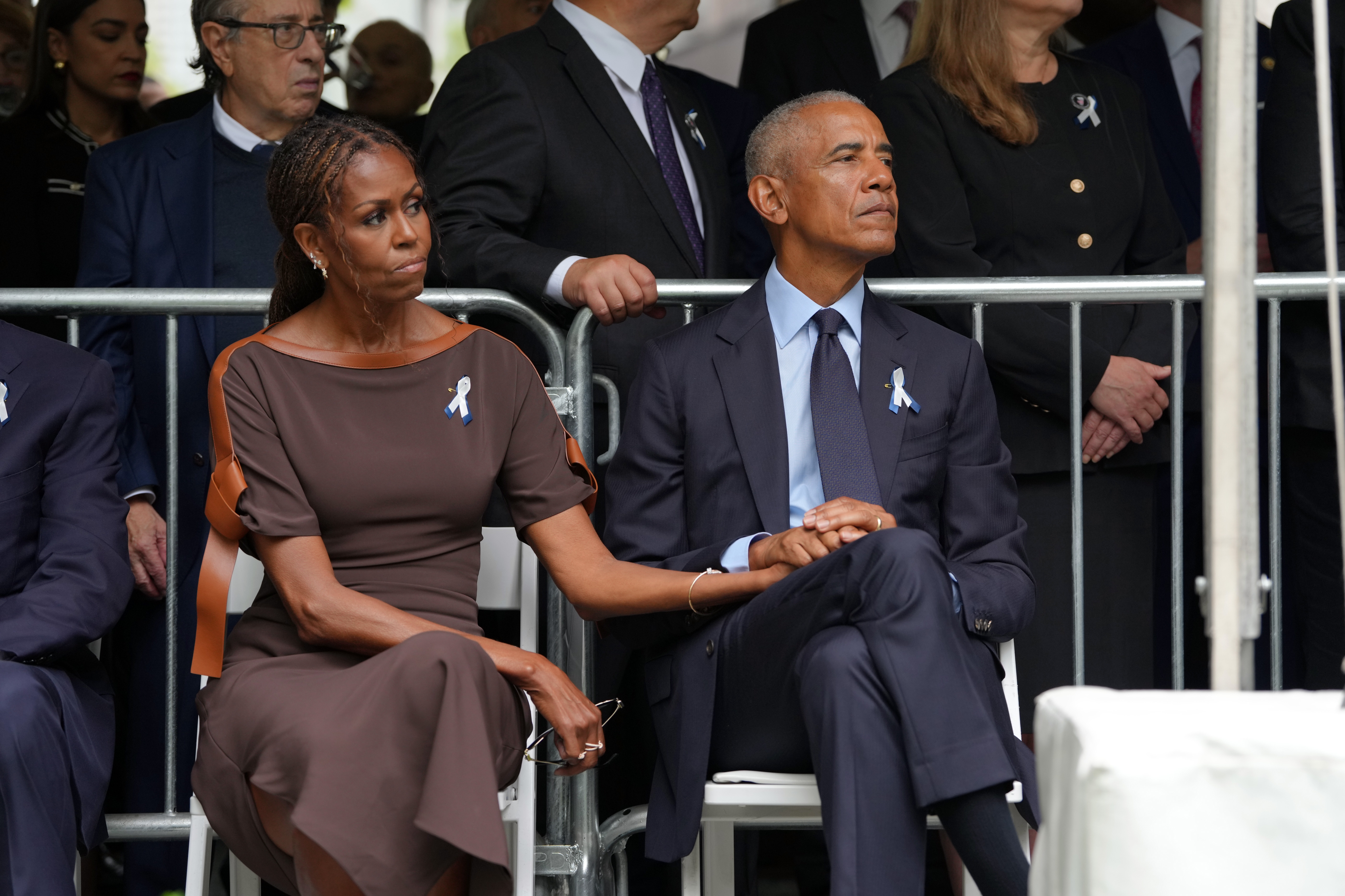 Michelle apoya la mano sobre la de Barack mientras están sentados juntos en una ceremonia pública, un discreto gesto de cariño que contrasta con los meses de especulaciones en torno a su matrimonio. | Fuente: Getty Images