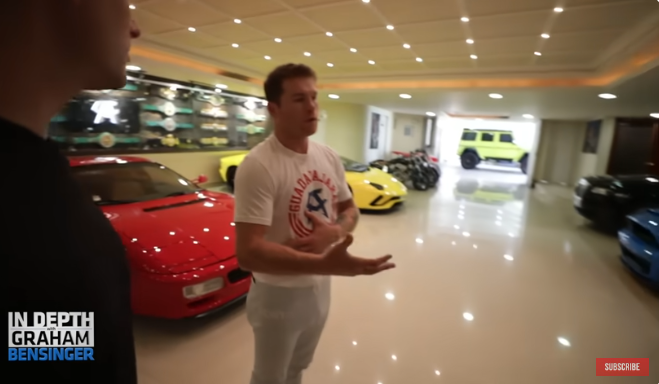 "Canelo" Álvarez muestra su garaje repleto de autos lujosos y una pared llena de cinturones de campeonatos de boxeo ganados. | Fuente: Youtube/Graham Bensinger.