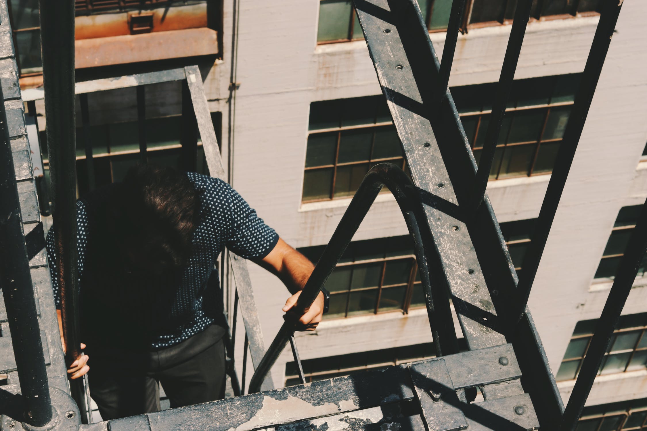 Hombre subiendo por escaleras de emergencia de un edificio. | Imagen: Pixabay