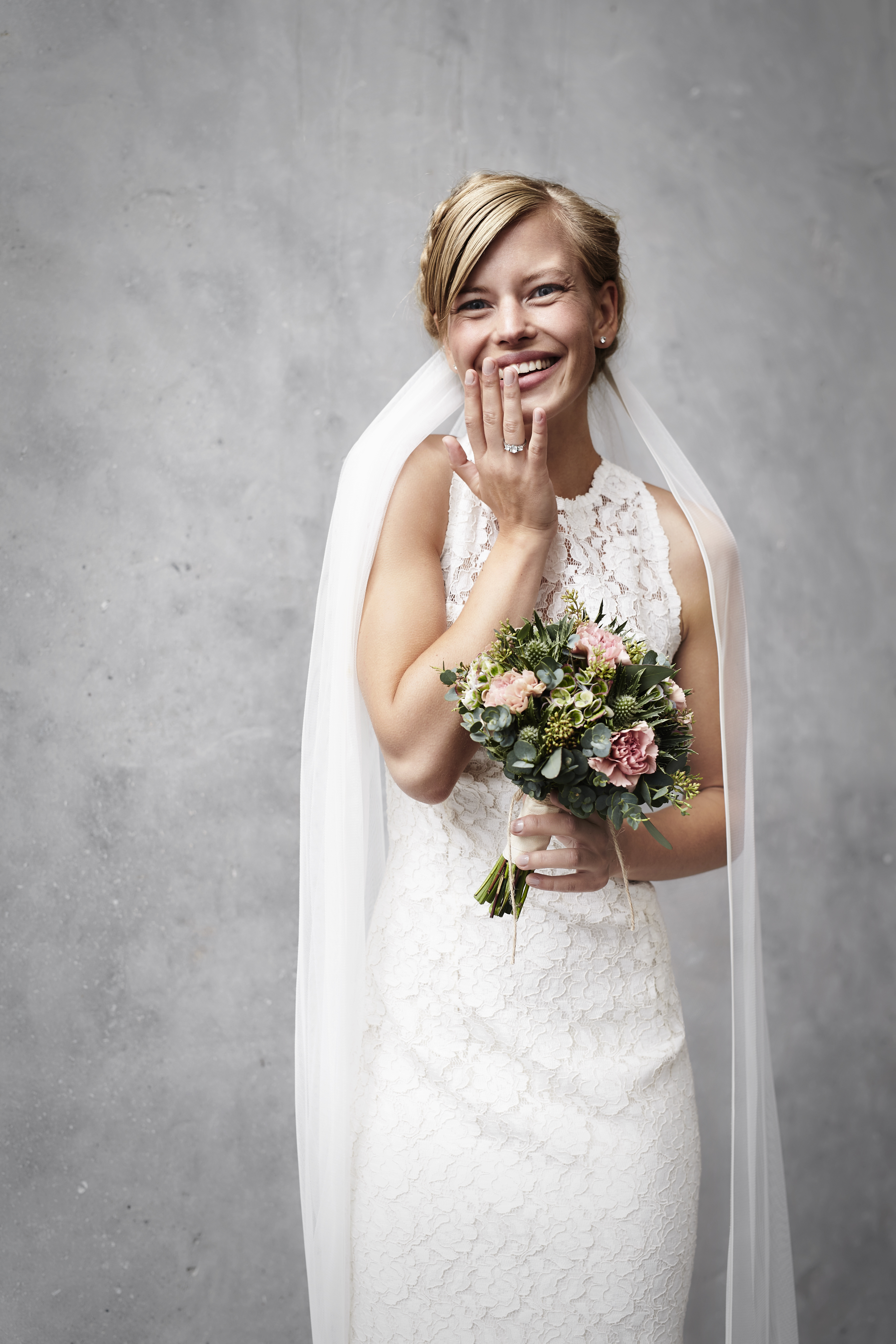 Una novia riendo mientras sostiene su ramo | Fuente: Shutterstock