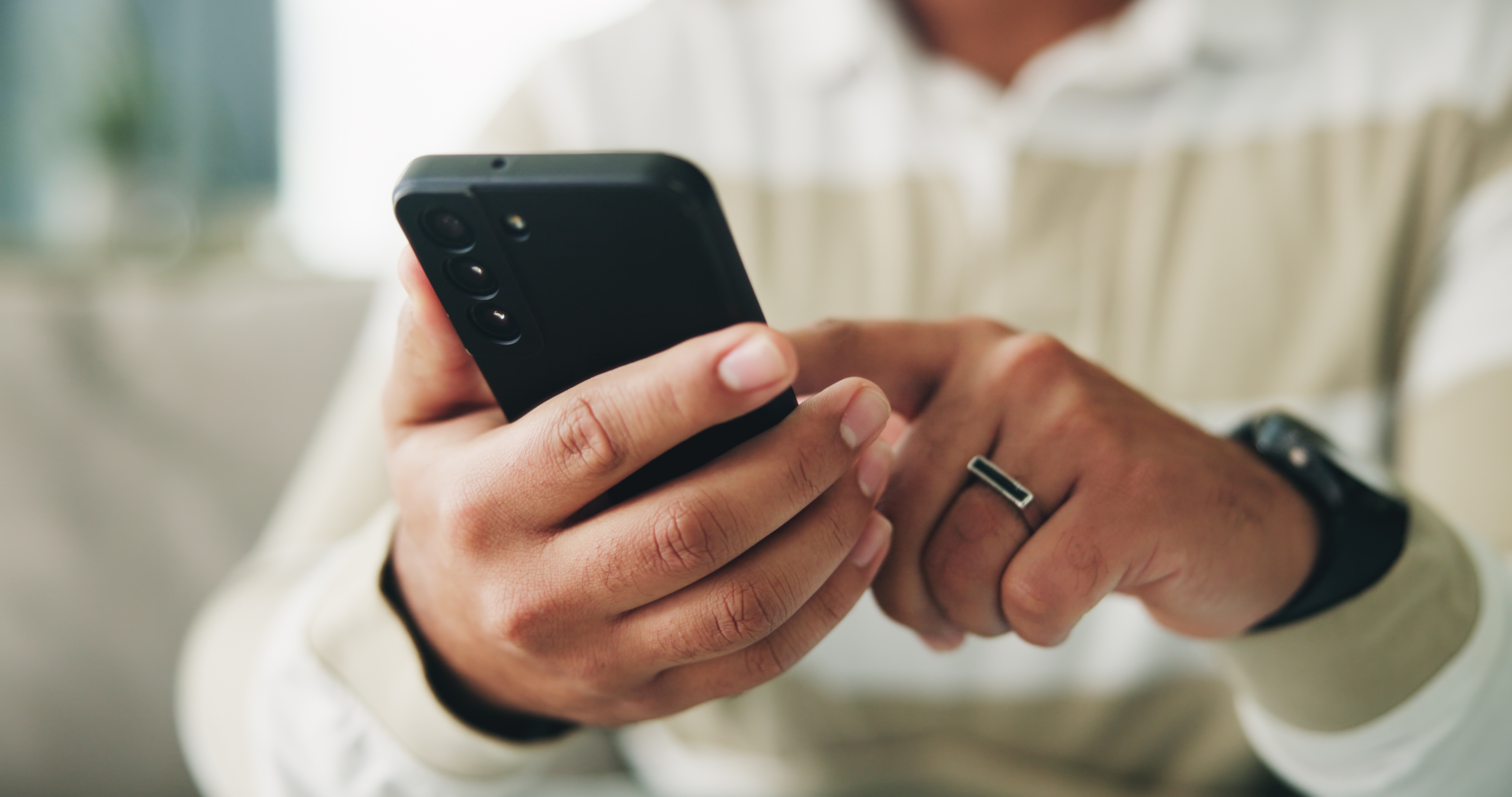 Hombre con un teléfono en la mano tocando la pantalla | Fuente: Shutterstock