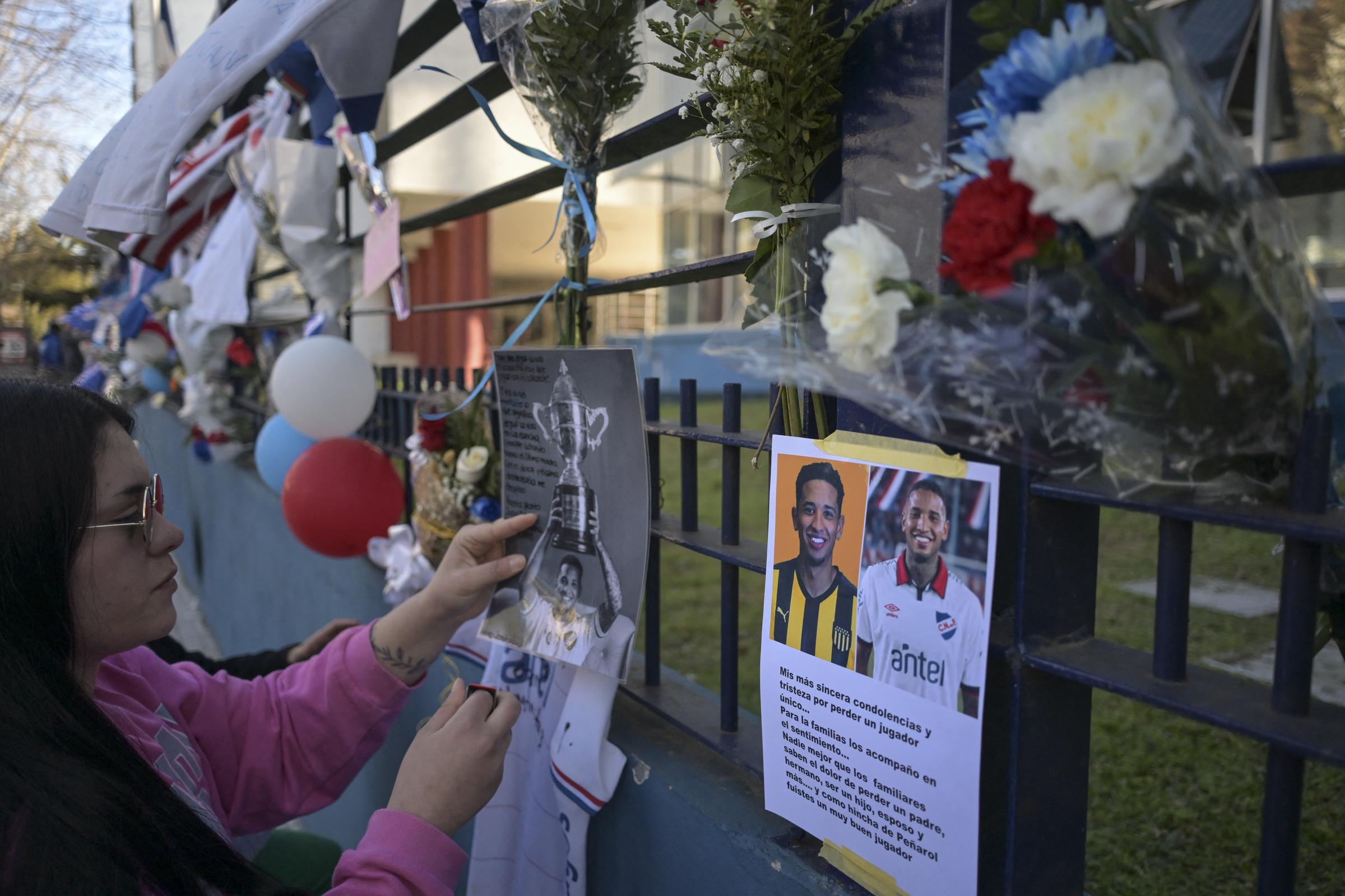 Una mujer rinde homenaje al fallecido futbolista de Nacional de Uruguay Juan Manuel Izquierdo en la sede del club en Montevideo, el 28 de agosto de 2024 | Fuente: Getty Images