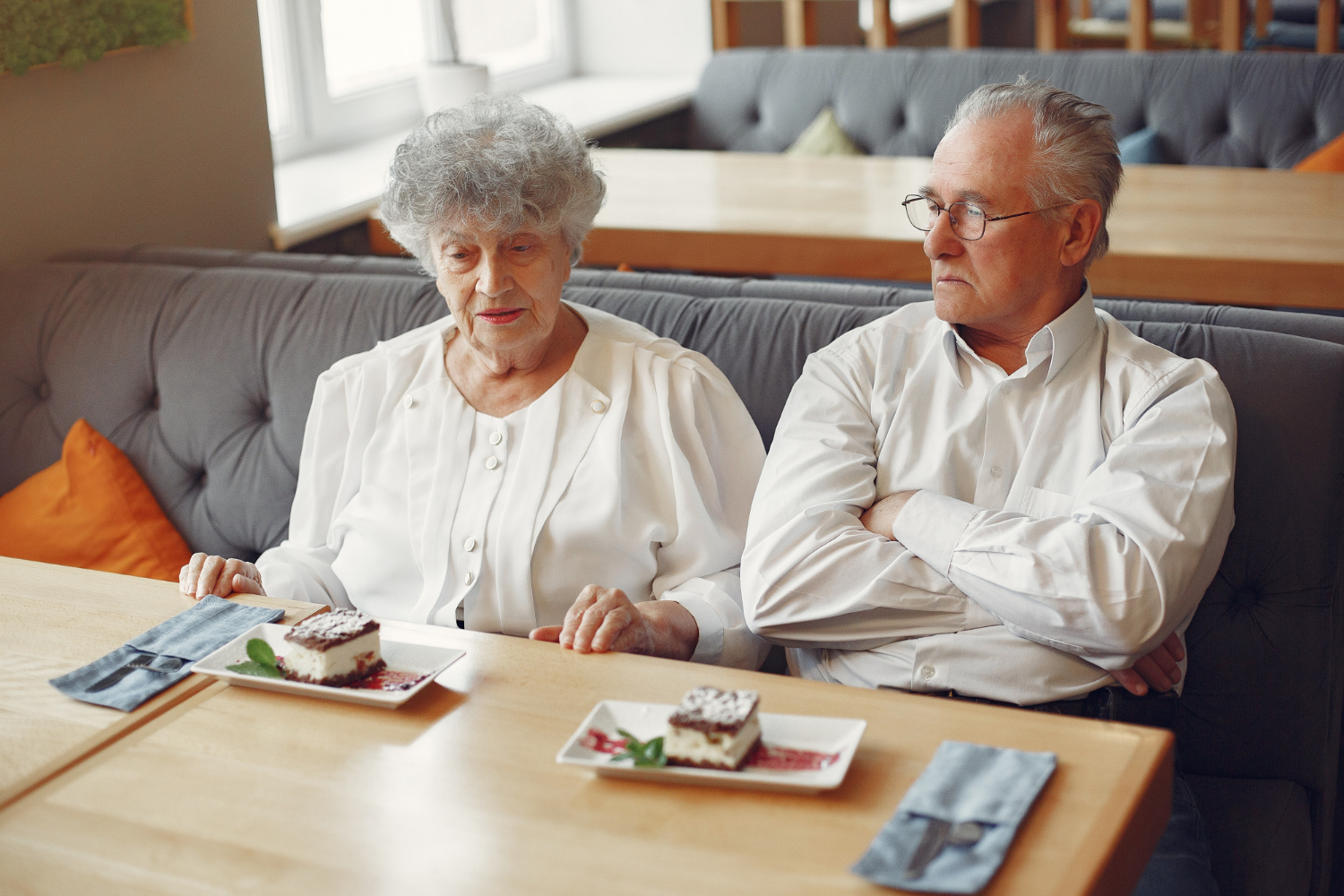 Una pareja de ancianos ansiosos sentados en un restaurante | Fuente: Freepik