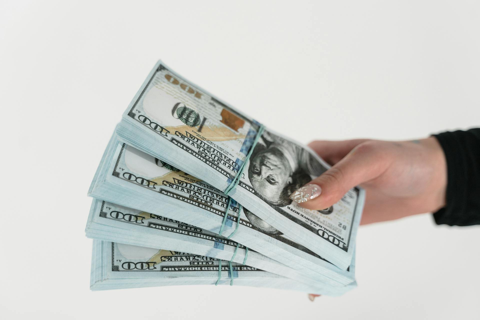 Una mujer con dinero en la mano | Fuente: Pexels
