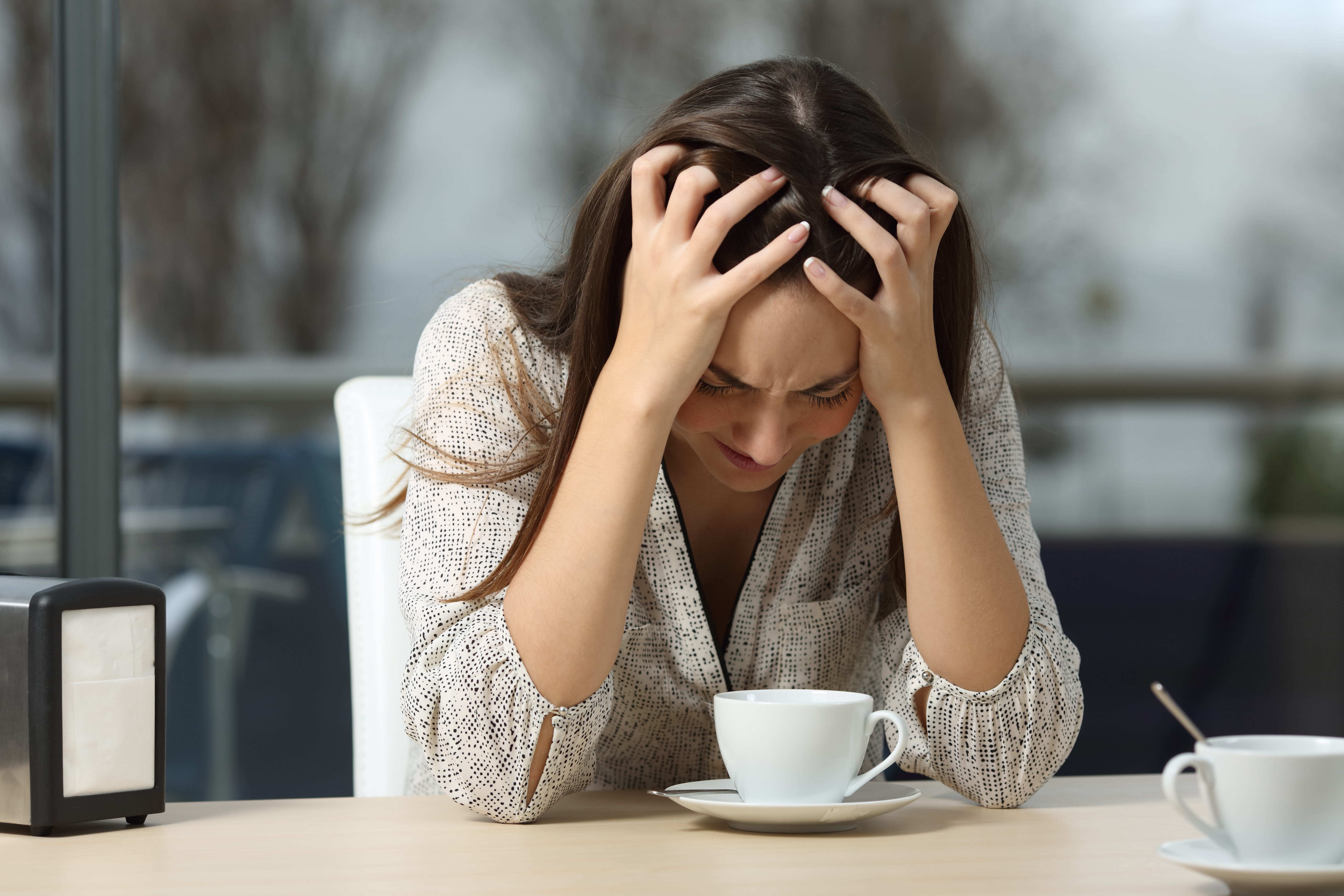 Mujer deprimida sentada sola en un café | Foto: Shutterstock