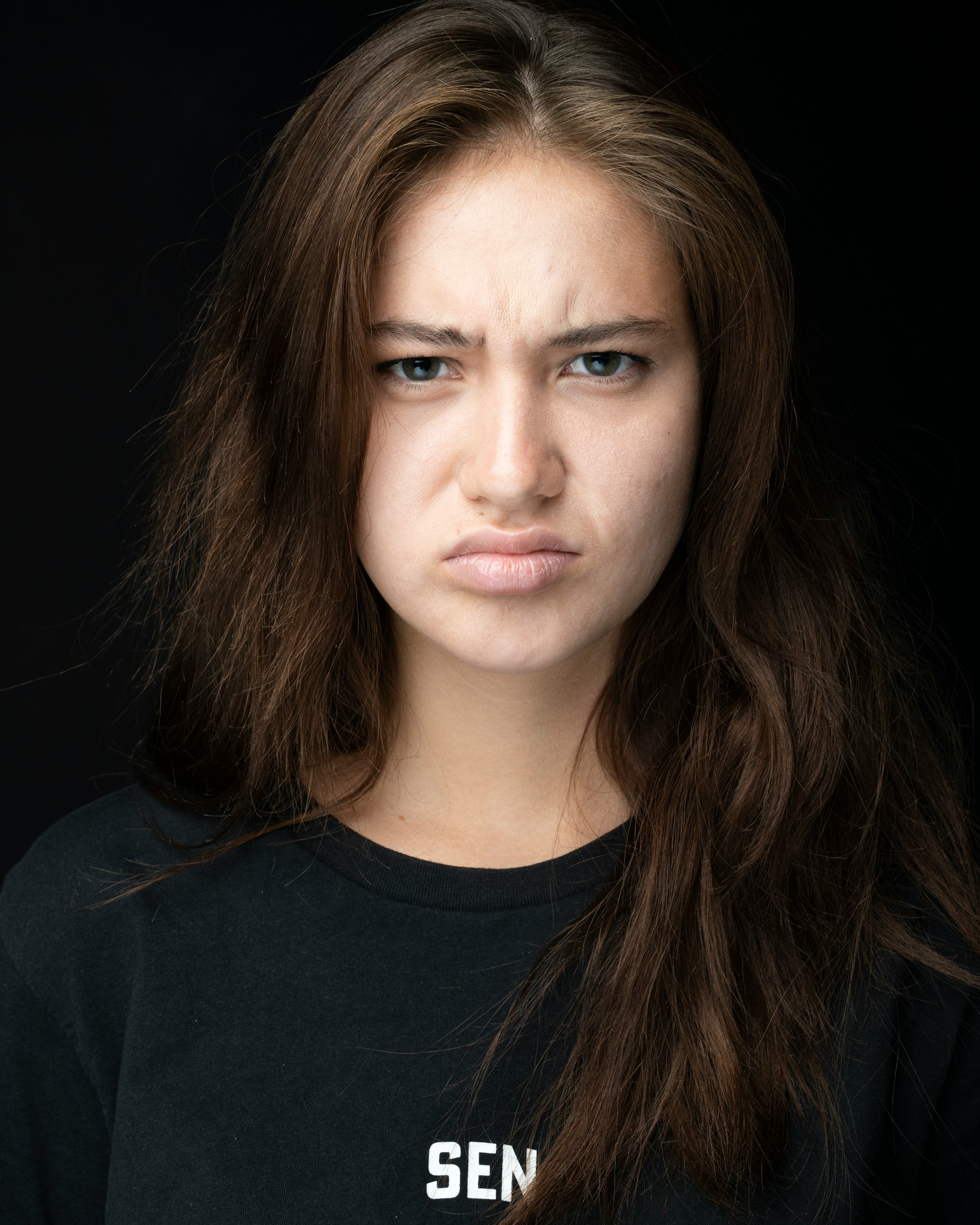 Una mujer con el ceño fruncido vestida de negro | Fuente: Unsplash