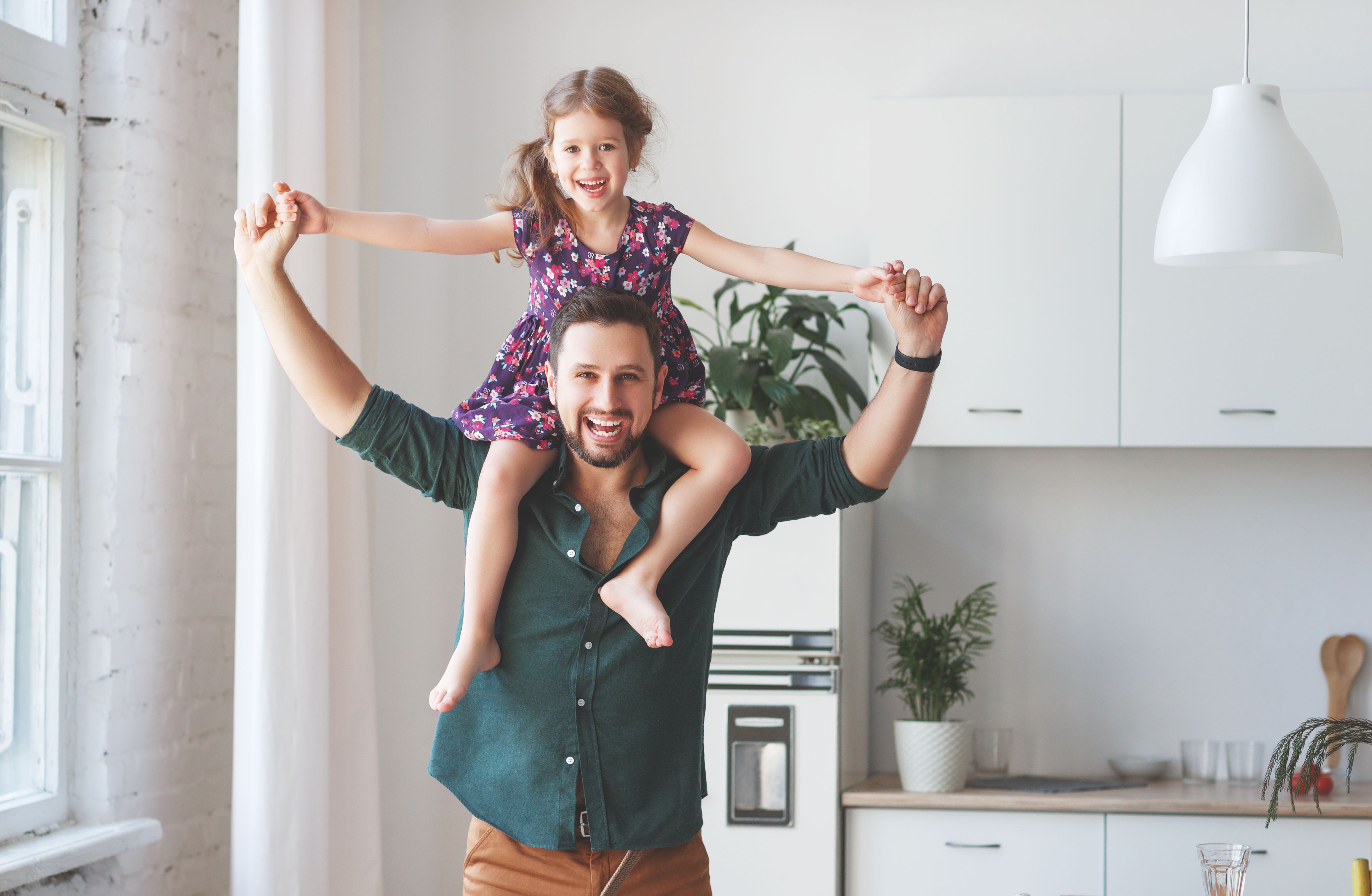 Un padre y su hija jugando en la sala de estar | Foto: Shutterstock