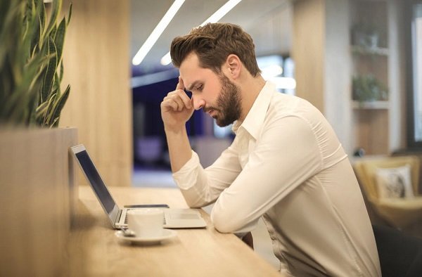 Hombre mirando pensativamente a una computadora portátil. |  Foto: Pexels