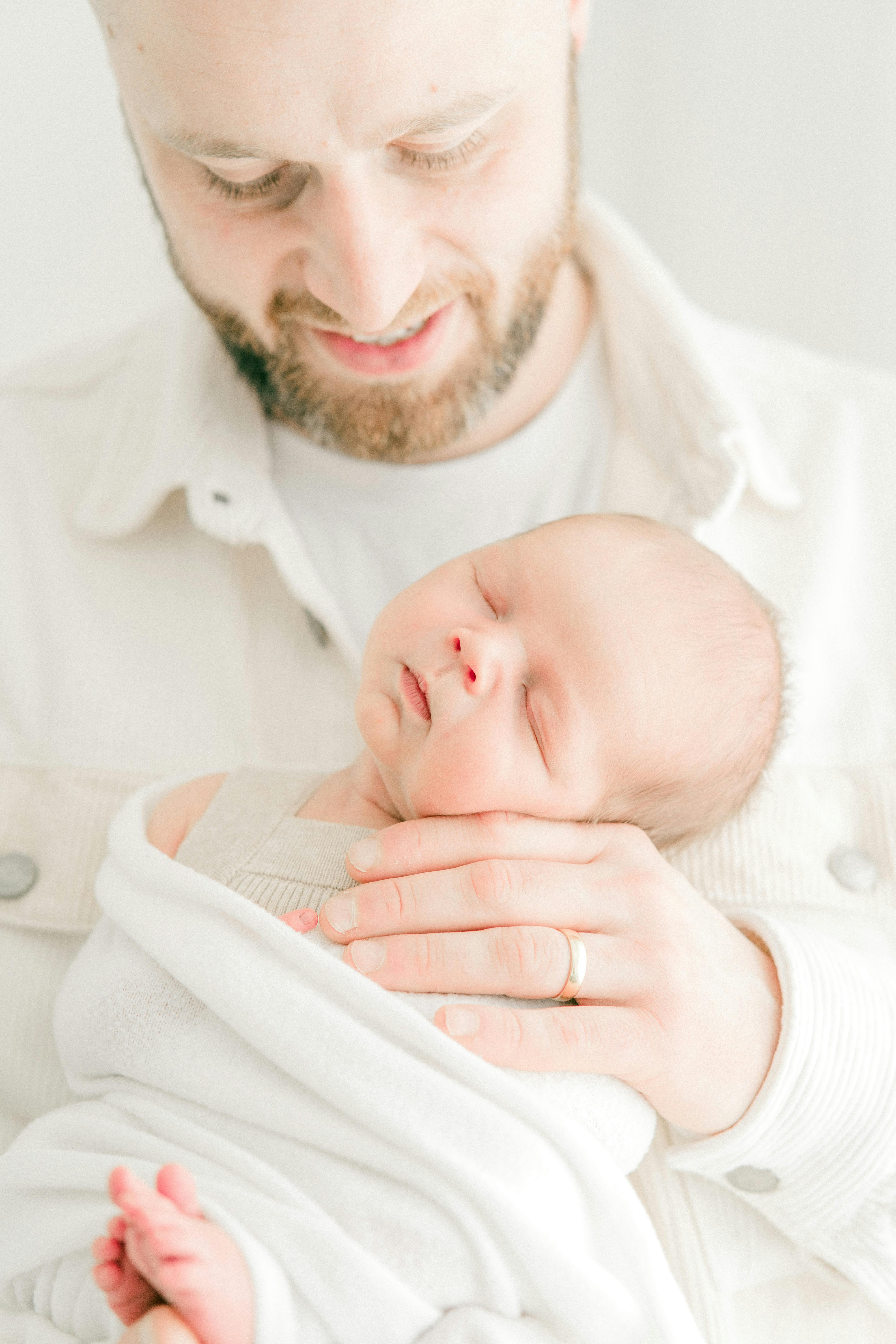 Un bebé recién nacido en brazos de un padre feliz | Fuente: Pexels