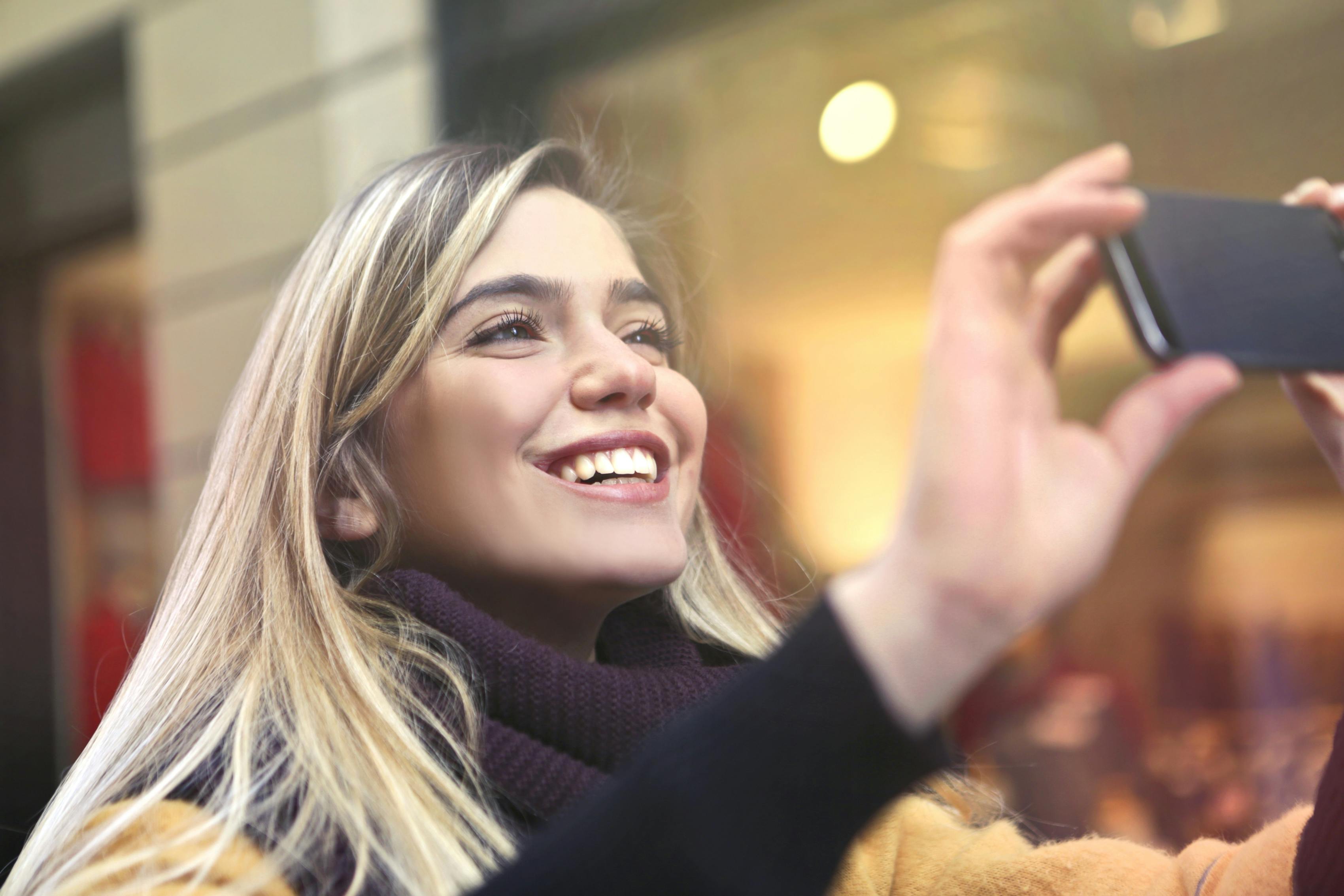 Una donna felice che scatta foto | Fonte: Pexels